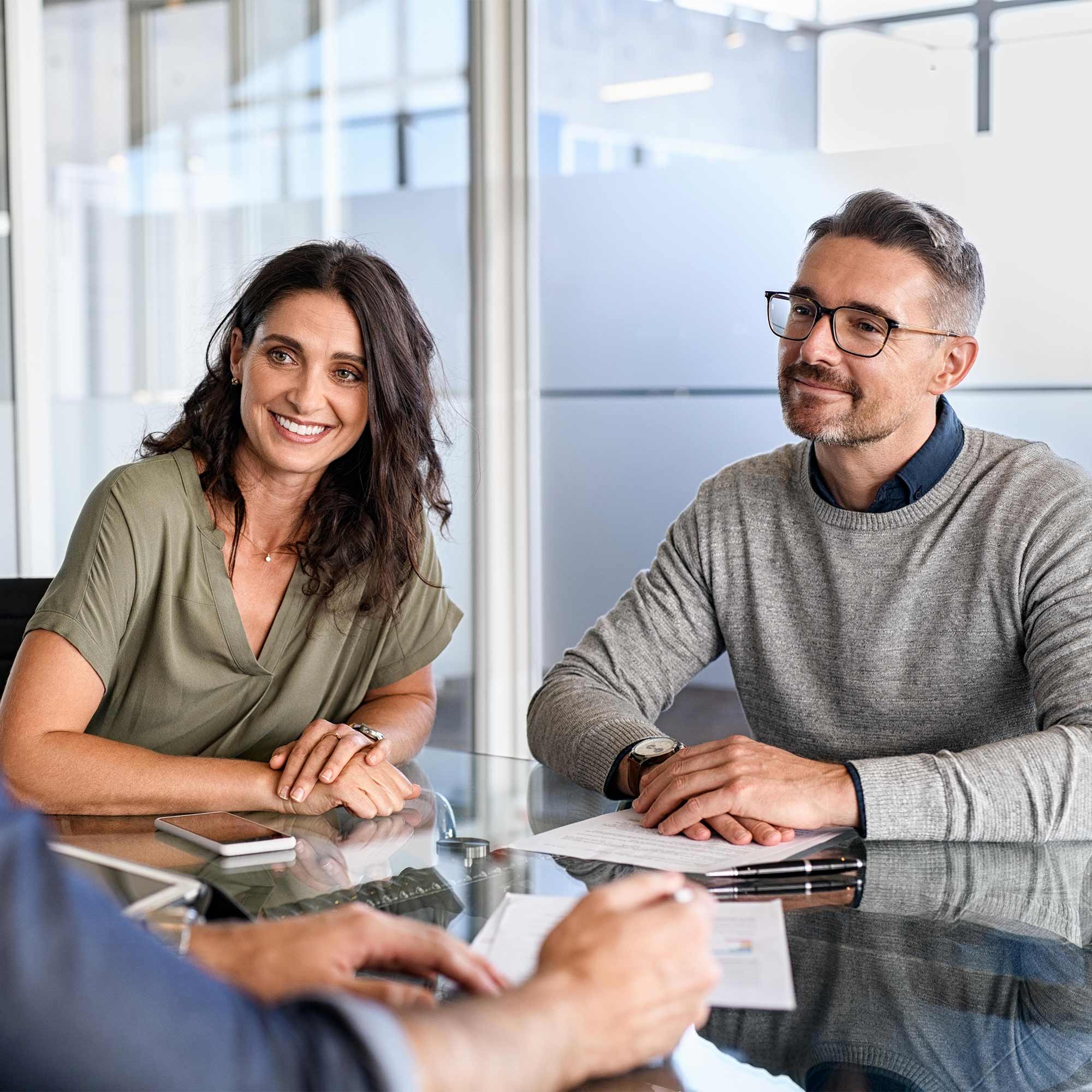 Man and woman sitting at desk smiling