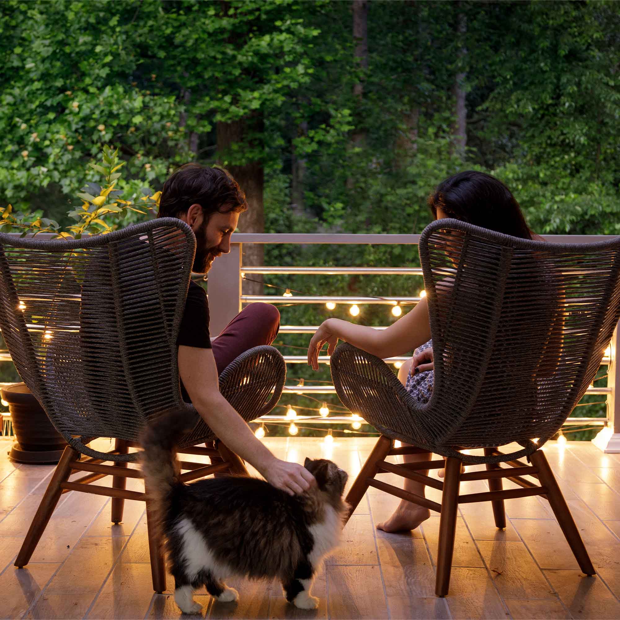 A couple sit on the patio enjoying the countryside view.