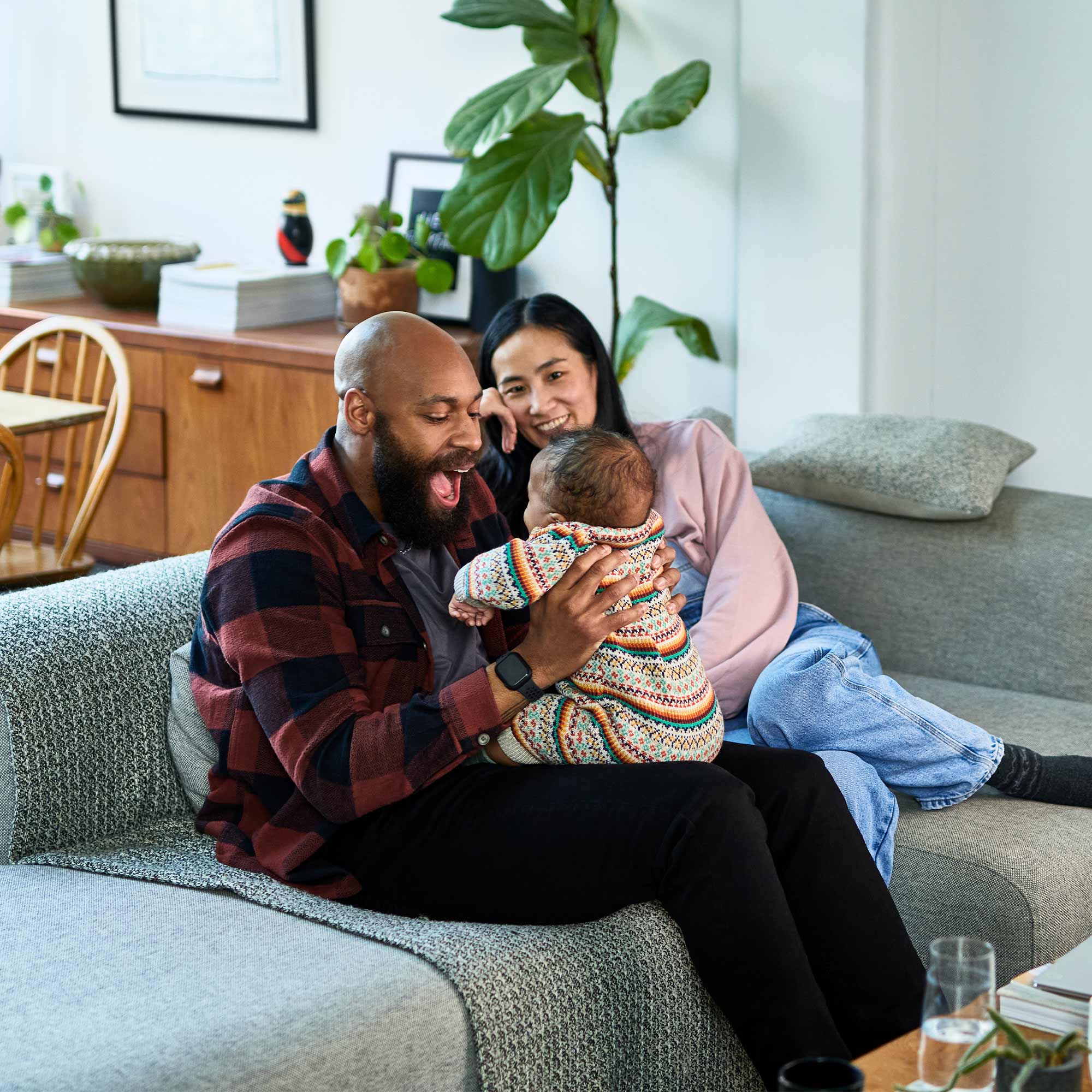 Two people carry a large cardboard box into a house together.