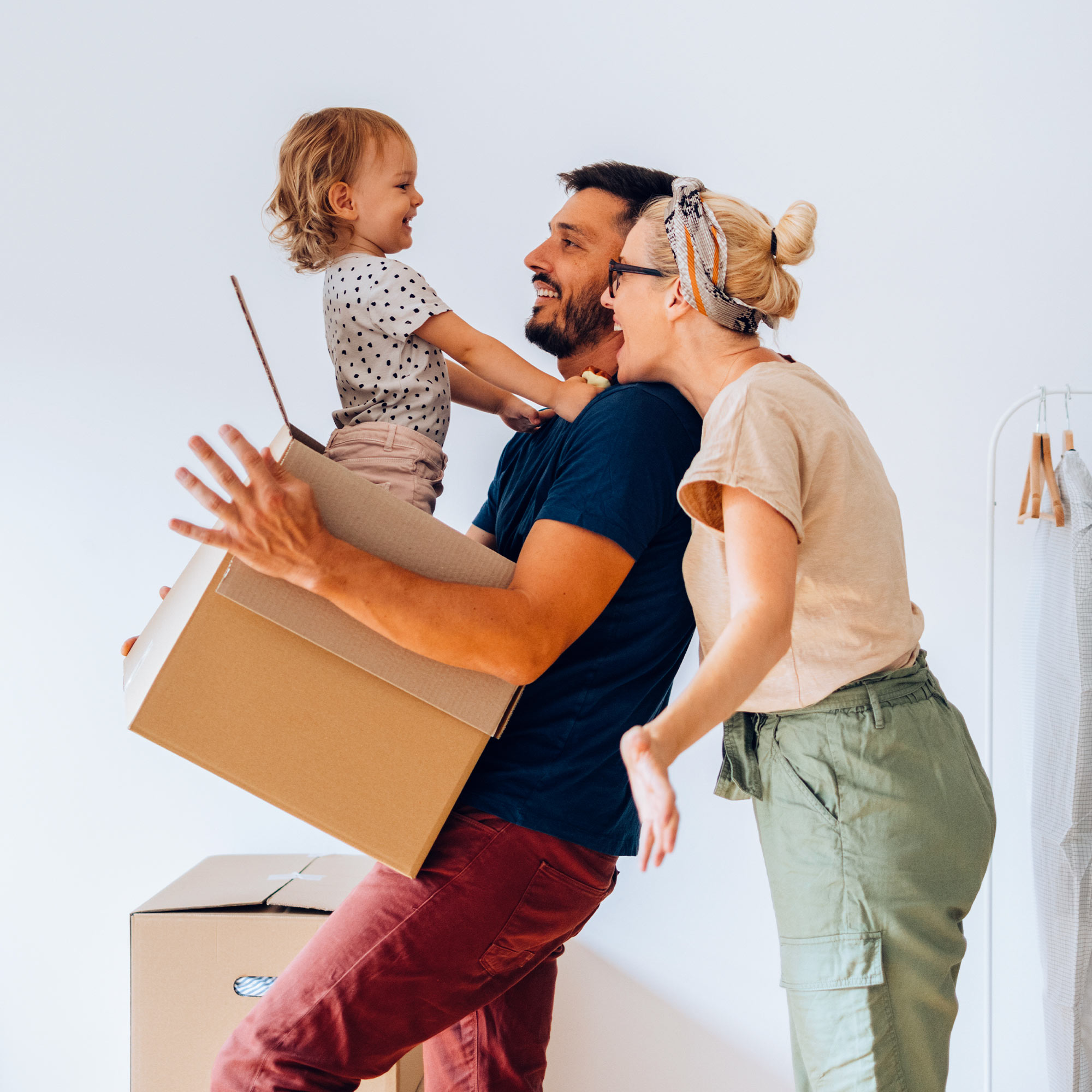 A family of three move packages into their new home.