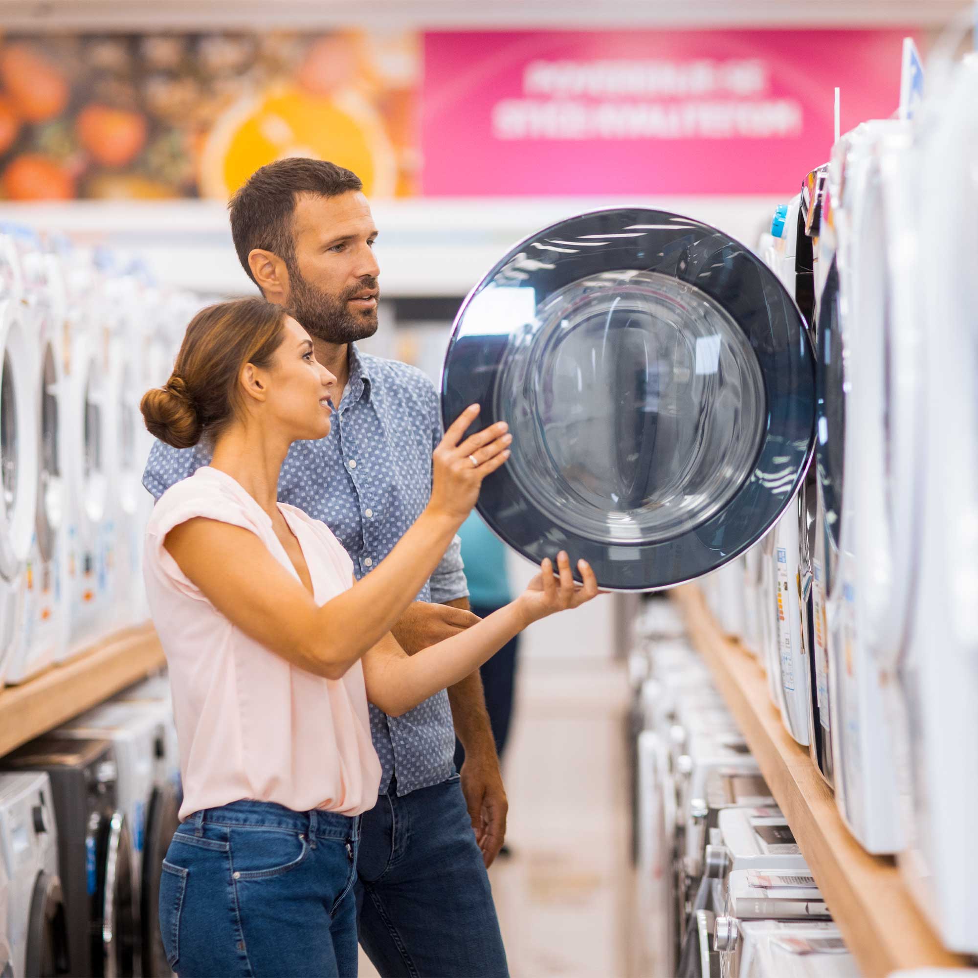 Couple looking at new washer and dryers.