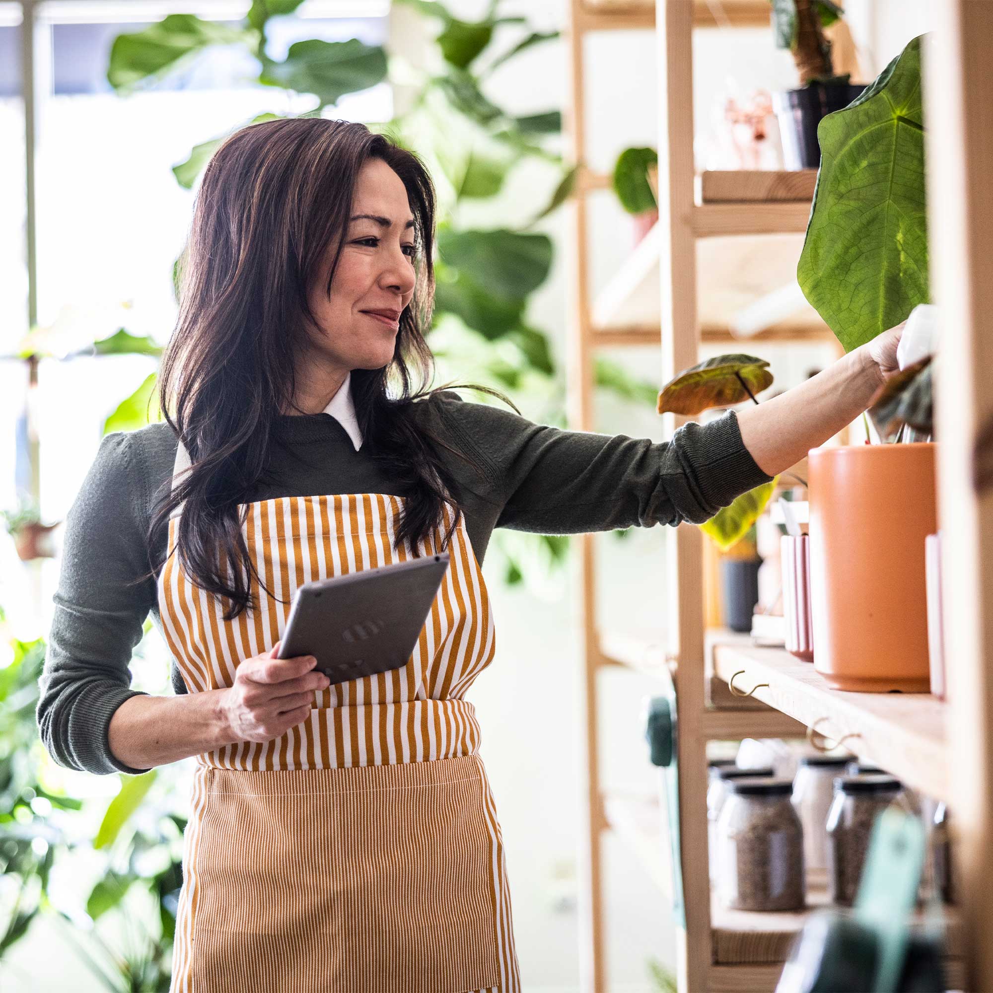 A woman smiles as she leans over and types into the computer.