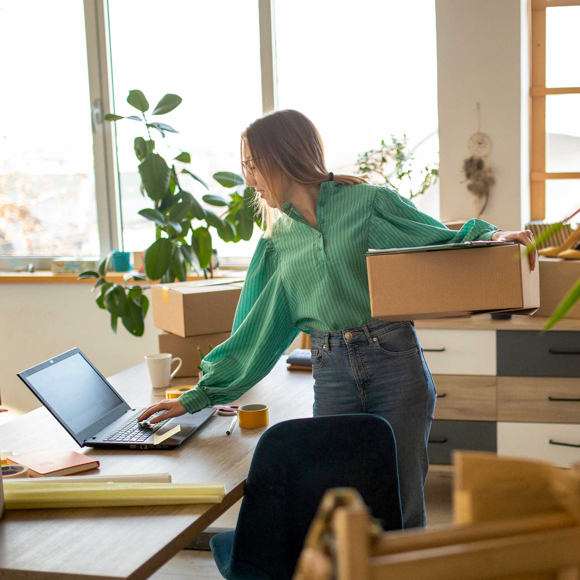 A woman wearing a white shirt and apron works behind the deli counter.
