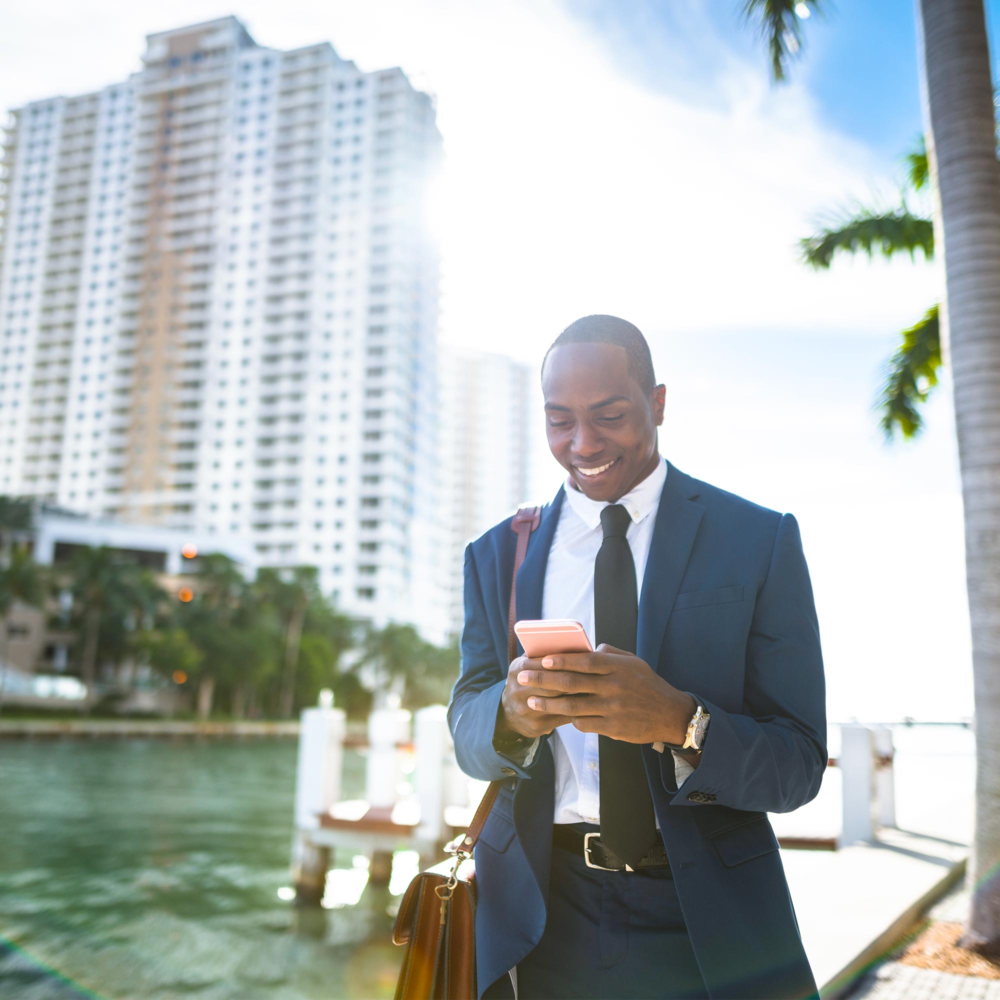 A doctor wearing blue gloves and white lab coat smiles in his office.