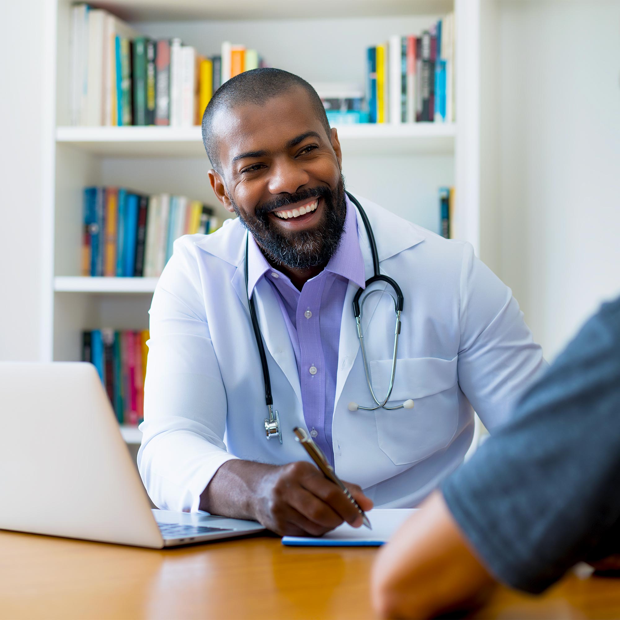A man in a business suit greets a couple as they step toward the plane.
