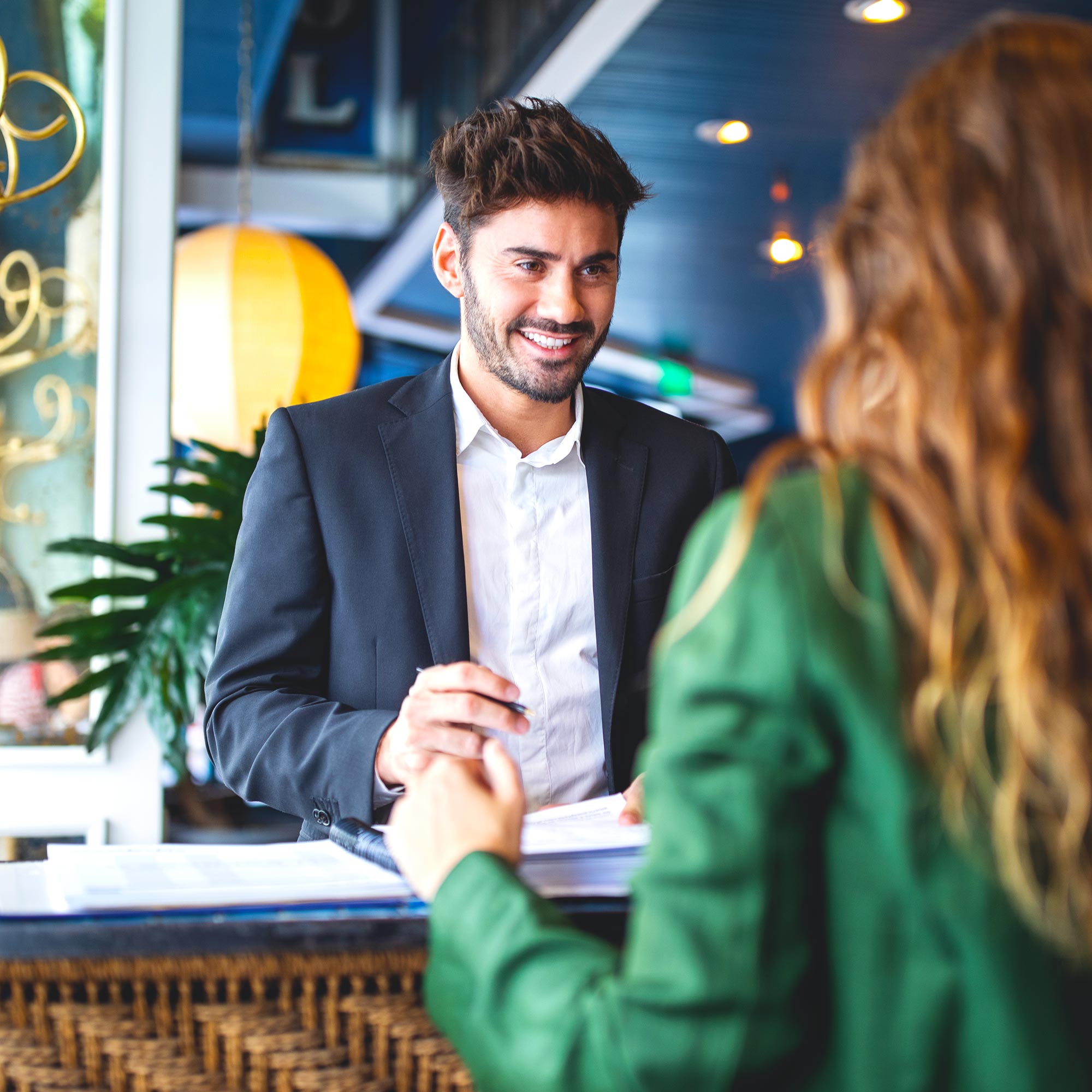 Professionally dressed man talking to a woman wearing a green shirt