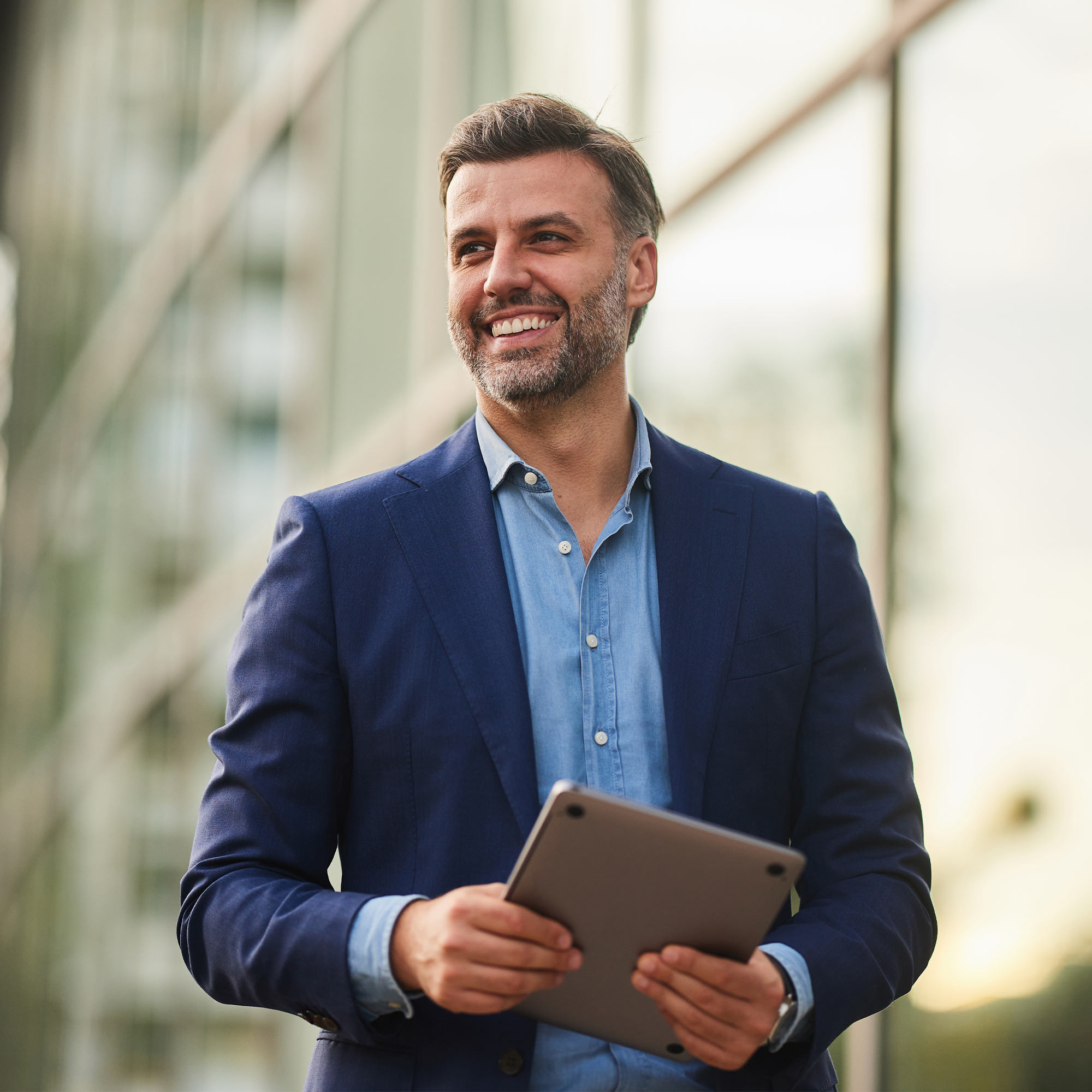 A man in a business suit smiles in conversation.
