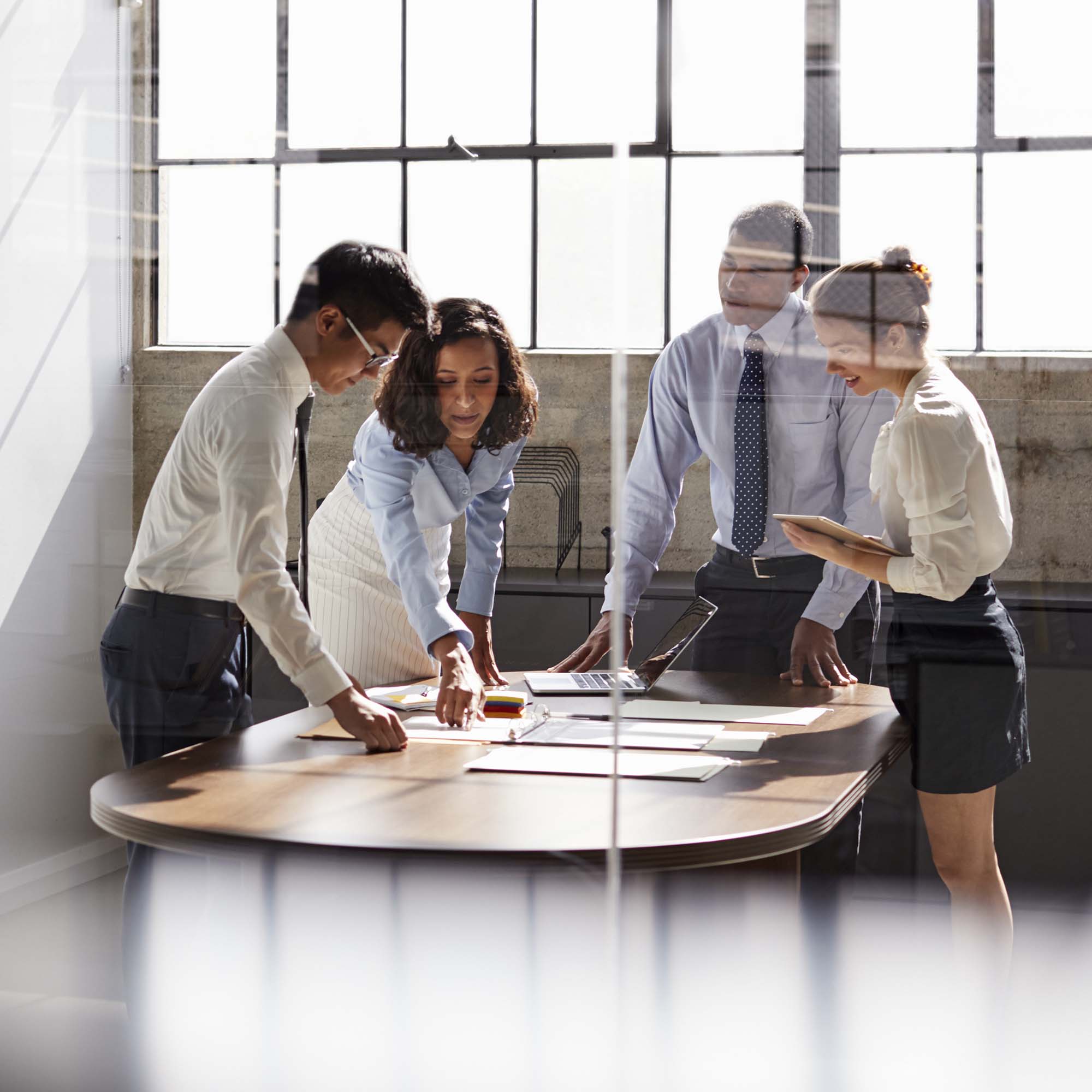 group of professional standing around a table discussing plans