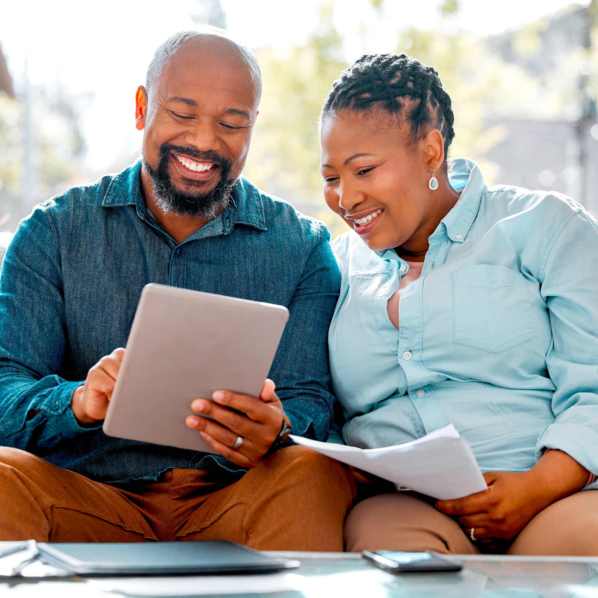 A man and woman look at their finances on a tablet