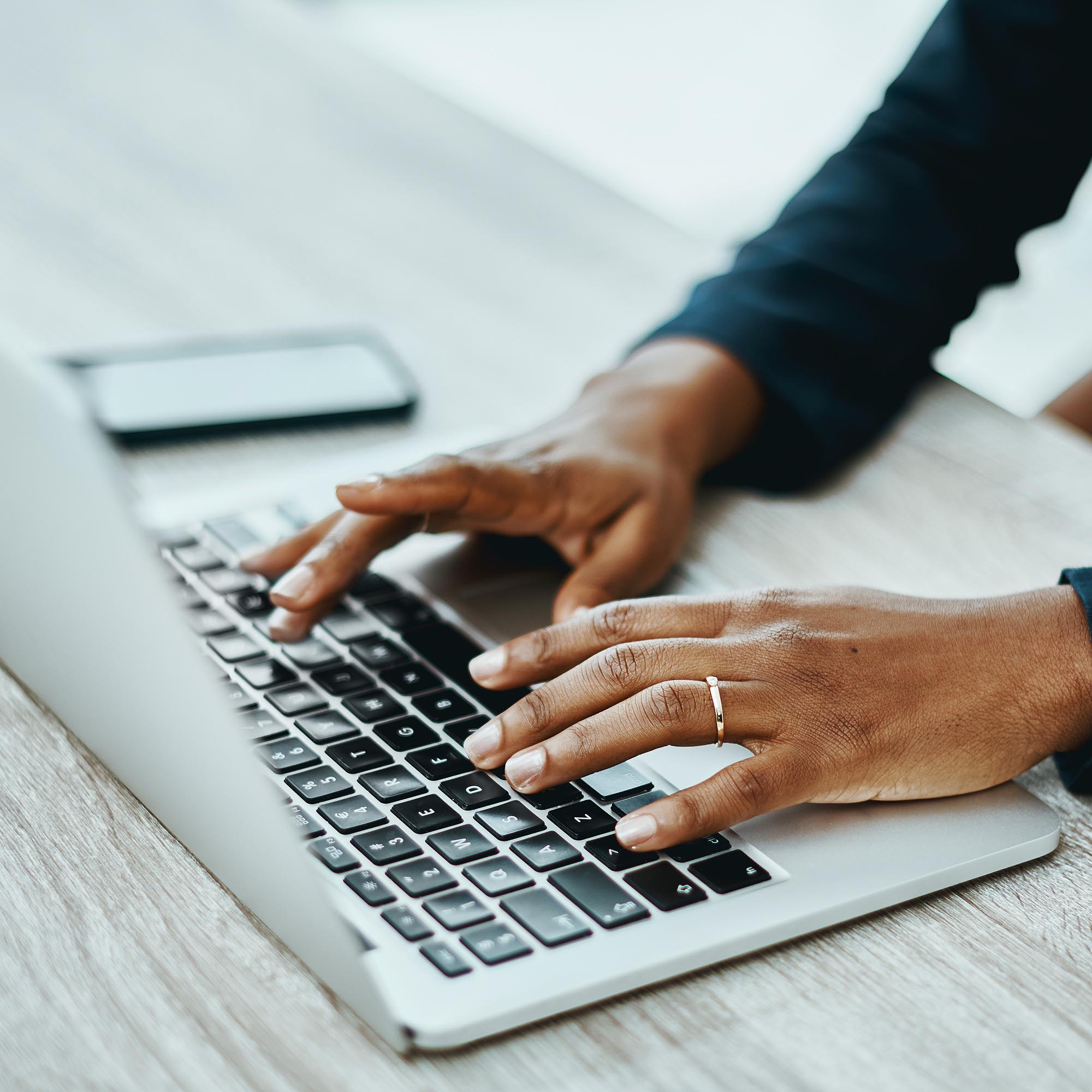 hands typing on a laptop keyboard