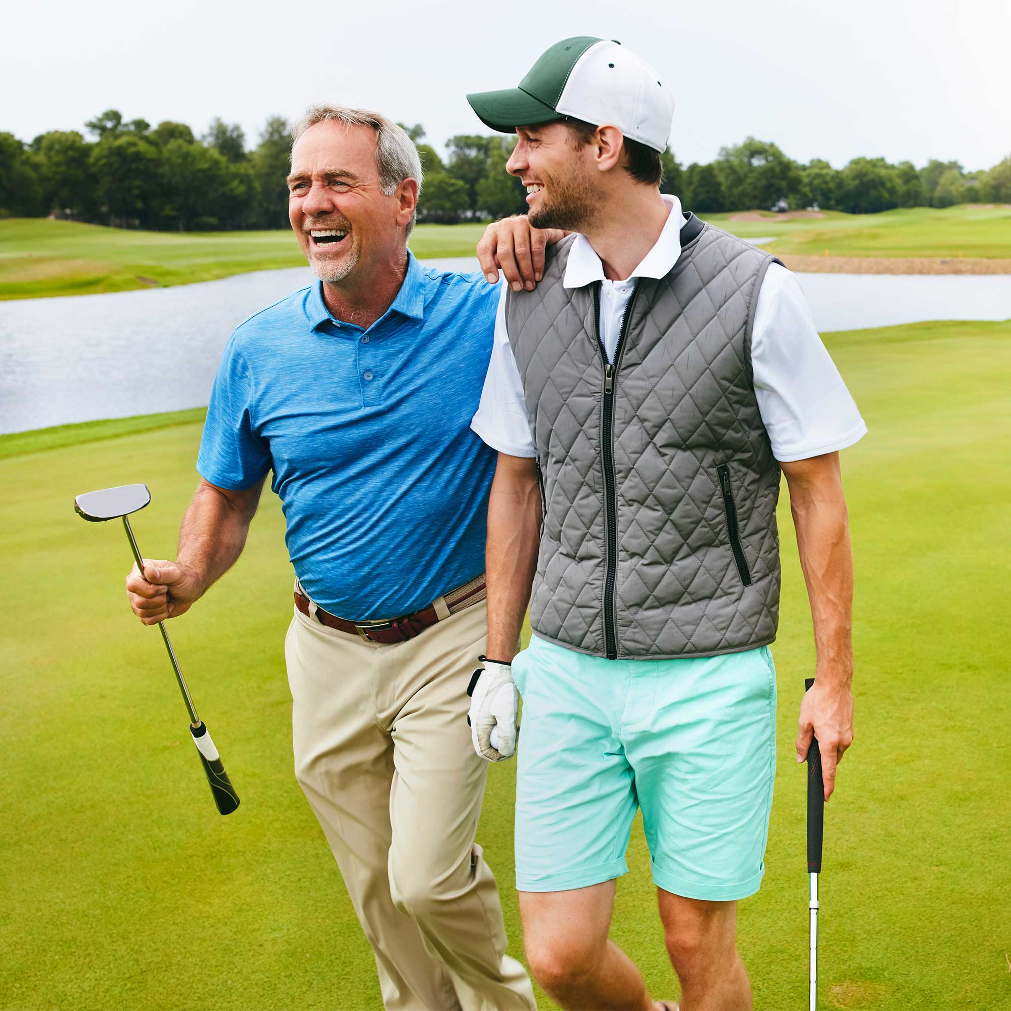 Two men laugh together after a game of golf.