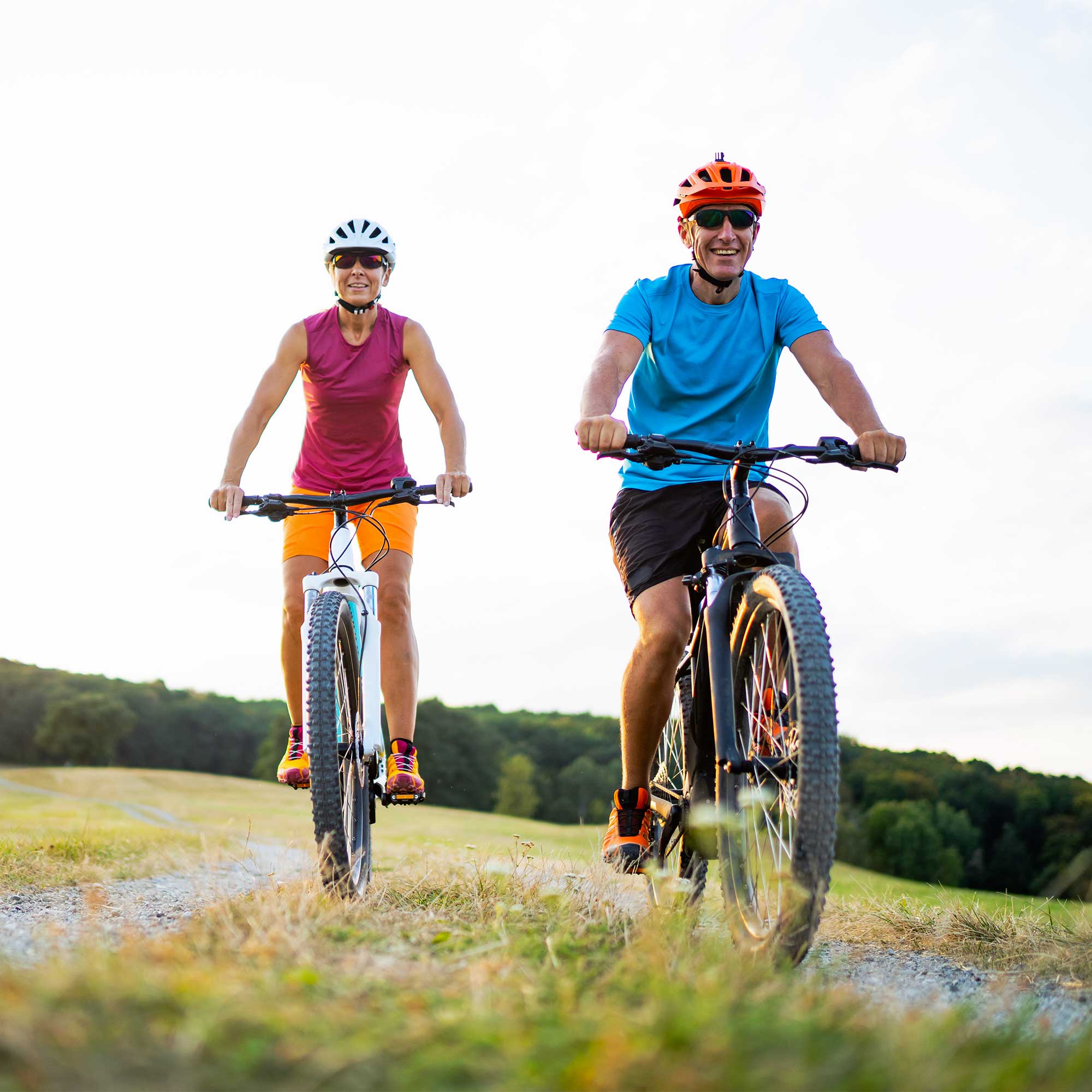 A man in a business suit smiles at a woman as she talks.