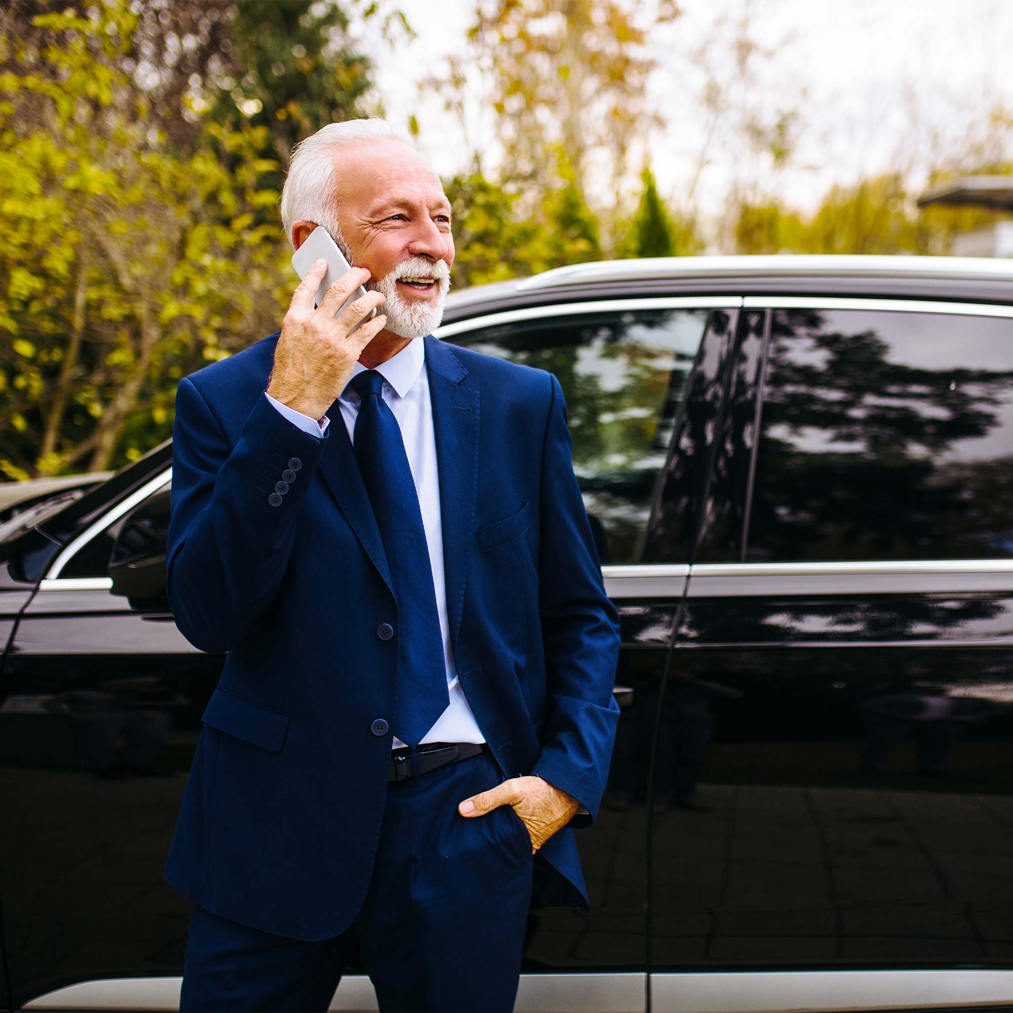 A professionally dressed man sits across the table from a woman and smiles.