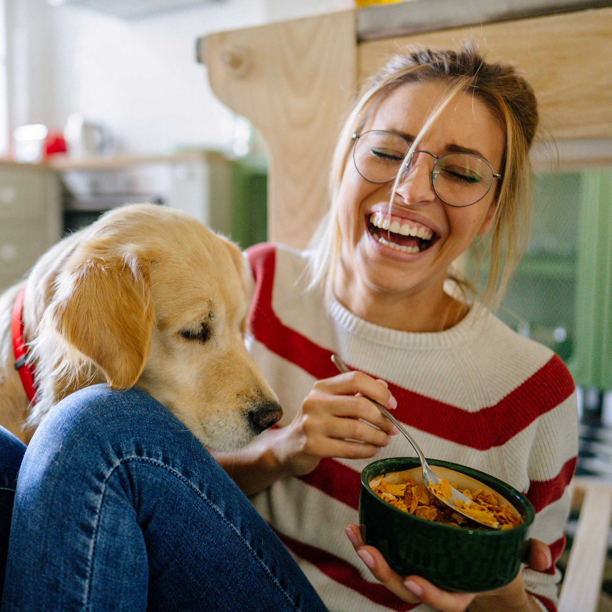 A man and a woman sitting on a bed using a computer.