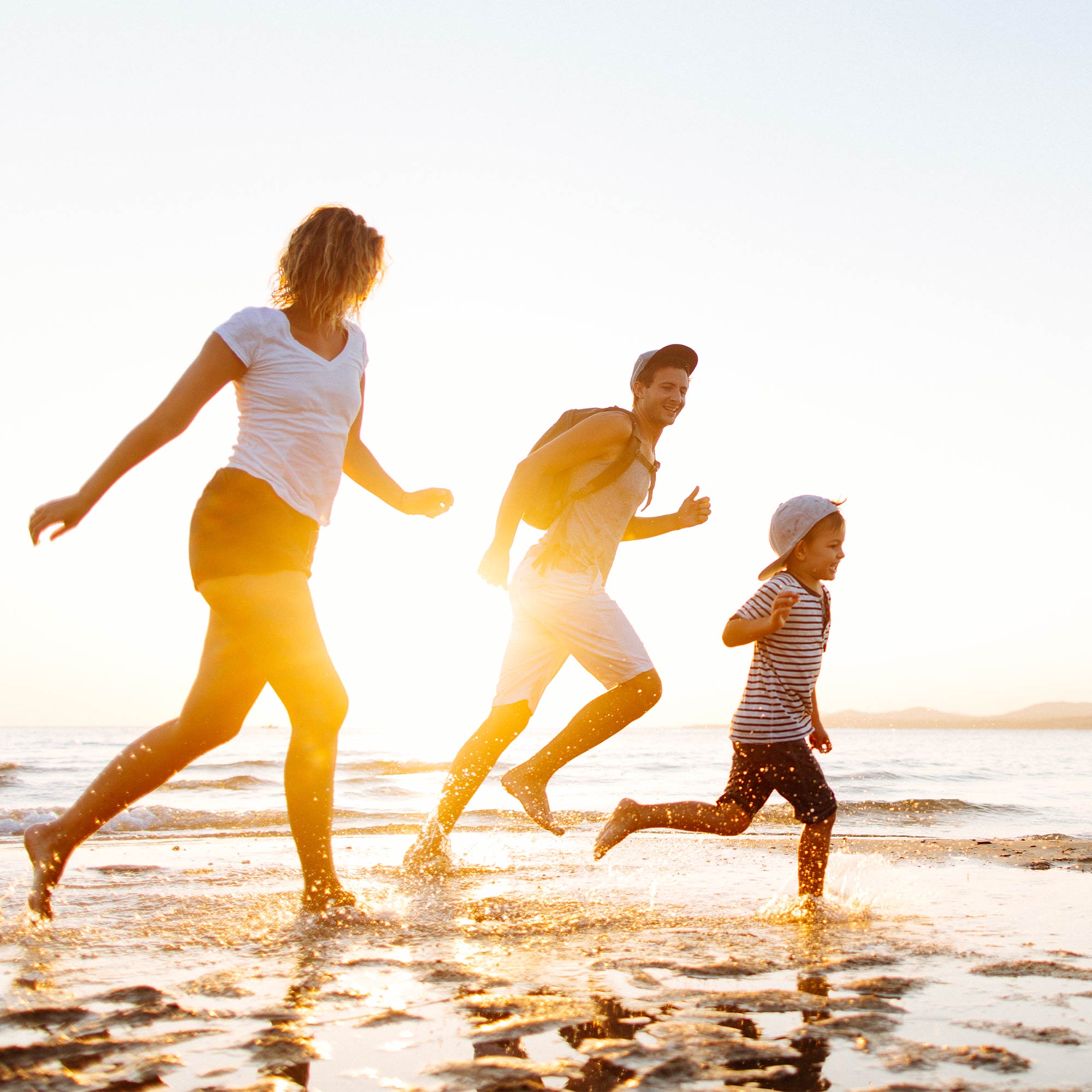A woman sits in her tent overlooking the valley as she smiles at her cell phone.