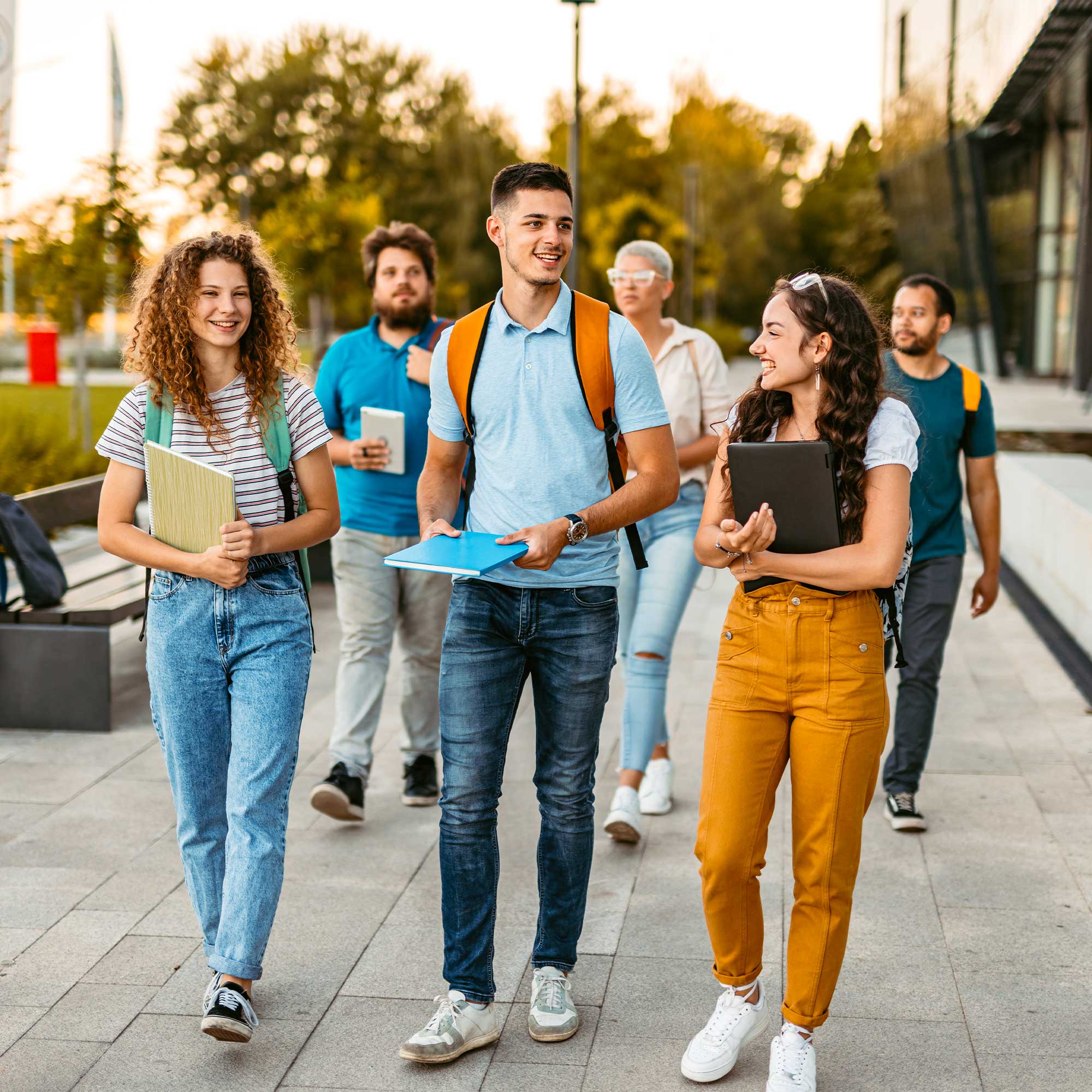 A group of students walking on a sidewalk together.