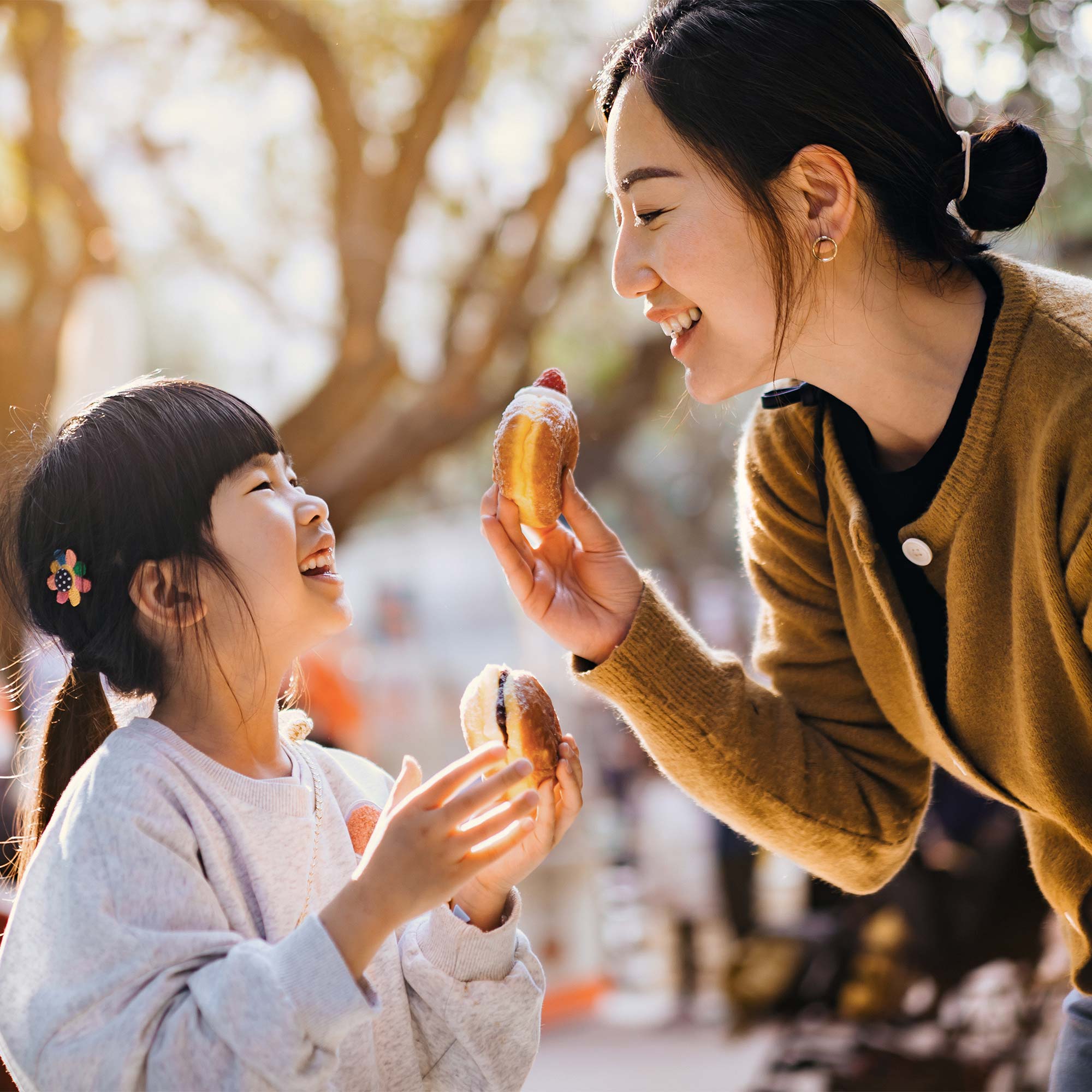 A father carries his young daughter as they grocery shop.