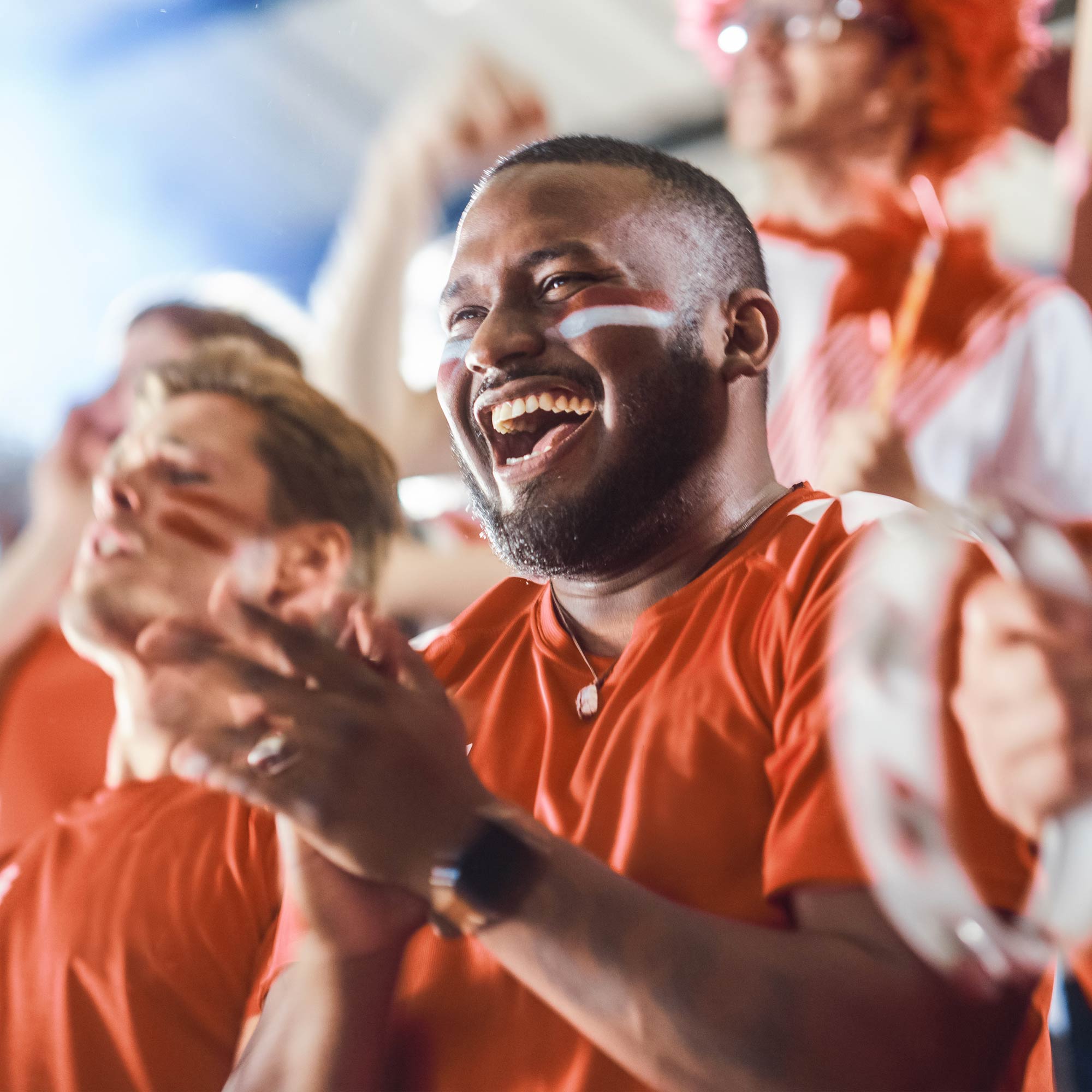 Group of guys sitting on the couch cheering and yelling at the tv.