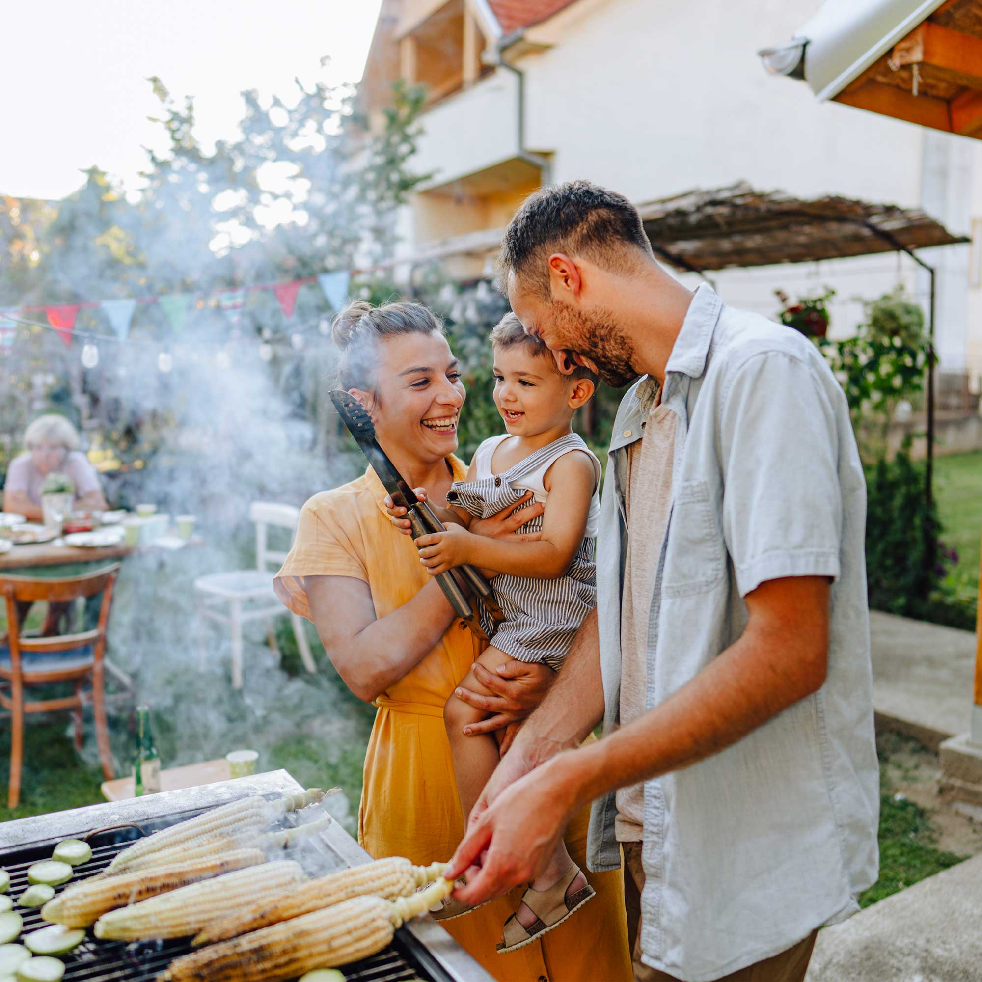 A woman wearing a dress smiles while using her contactless payment.