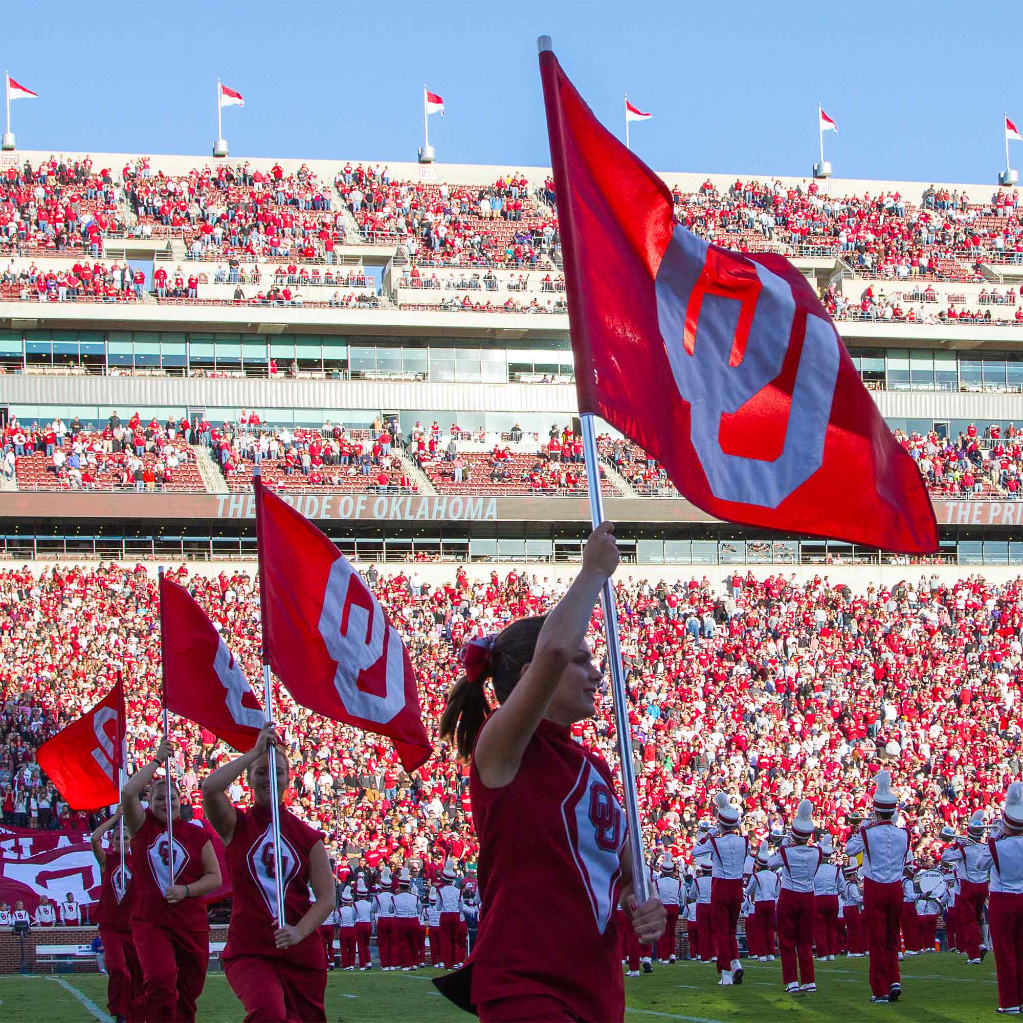 OU students holding flags at OU football game