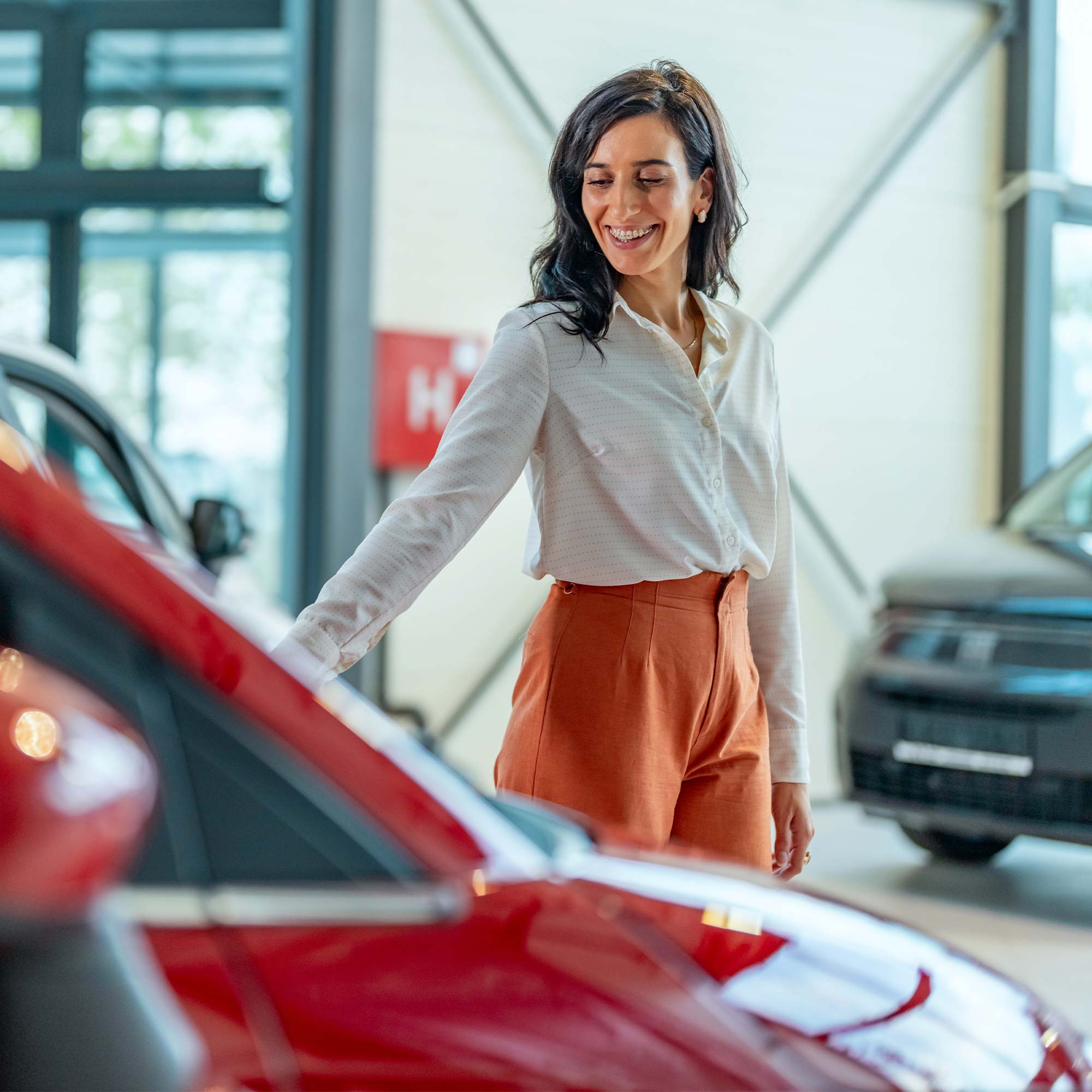 A man, woman and child are shopping for a car at the dealership.