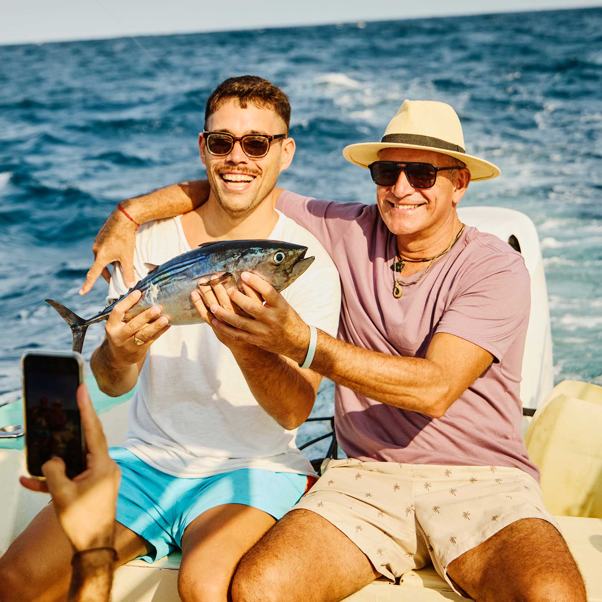 A man and a woman sit on the boat deck and enjoy the view.