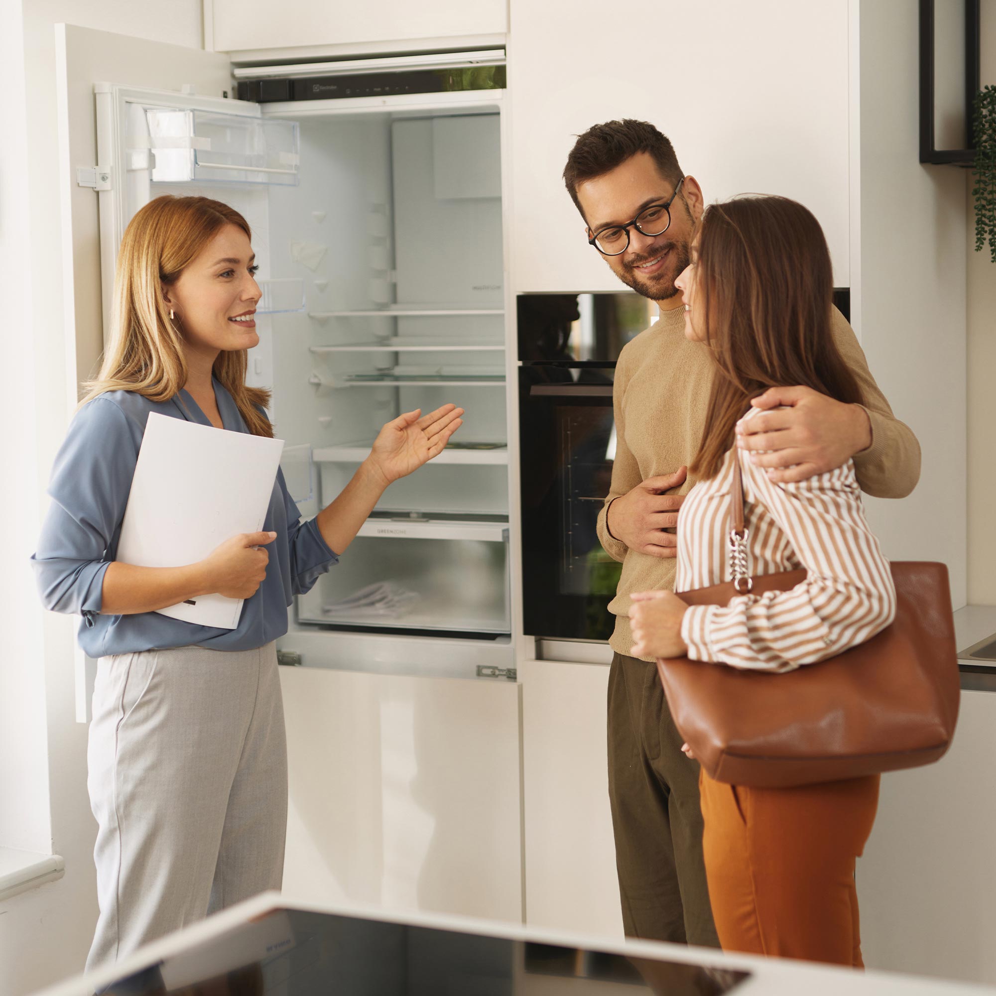 A family of three carrying boxes into their new home.