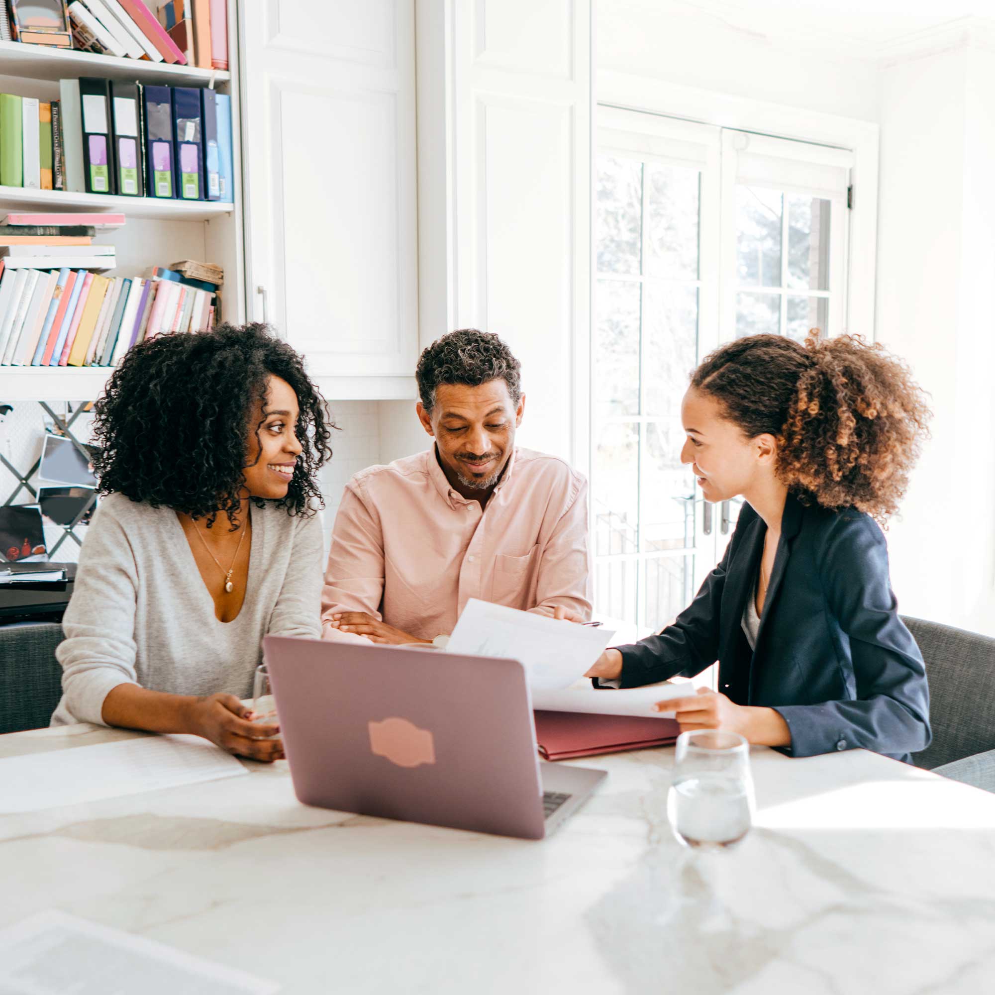 A group of people review documents at a table.