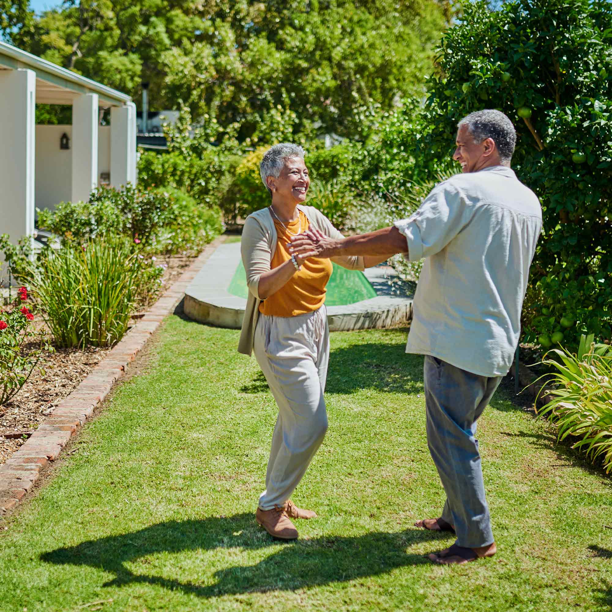 A woman and man dance together in their backyard.