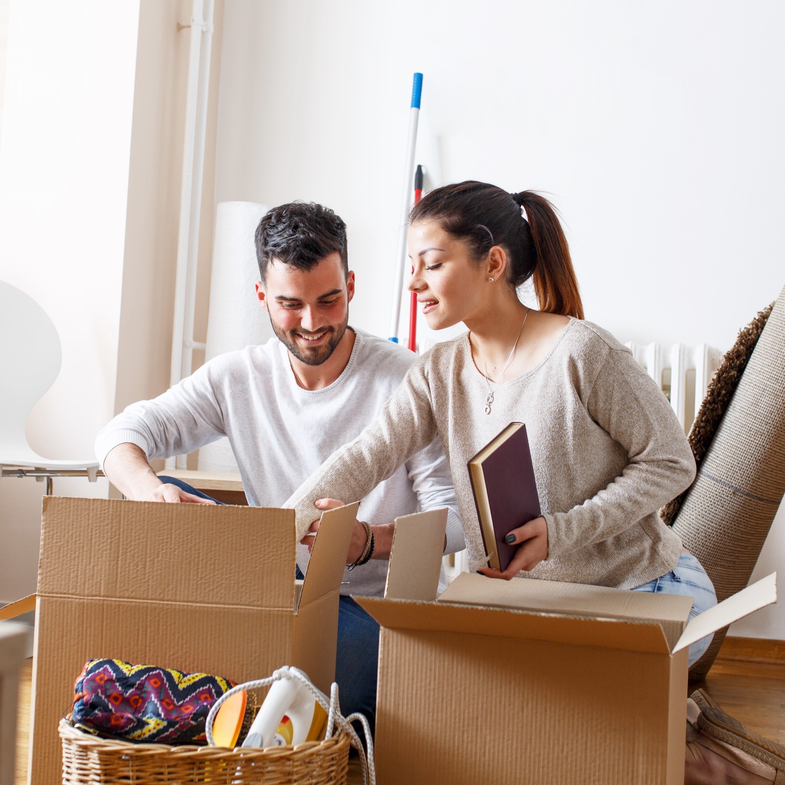 A man and woman unpack boxes in their new home.