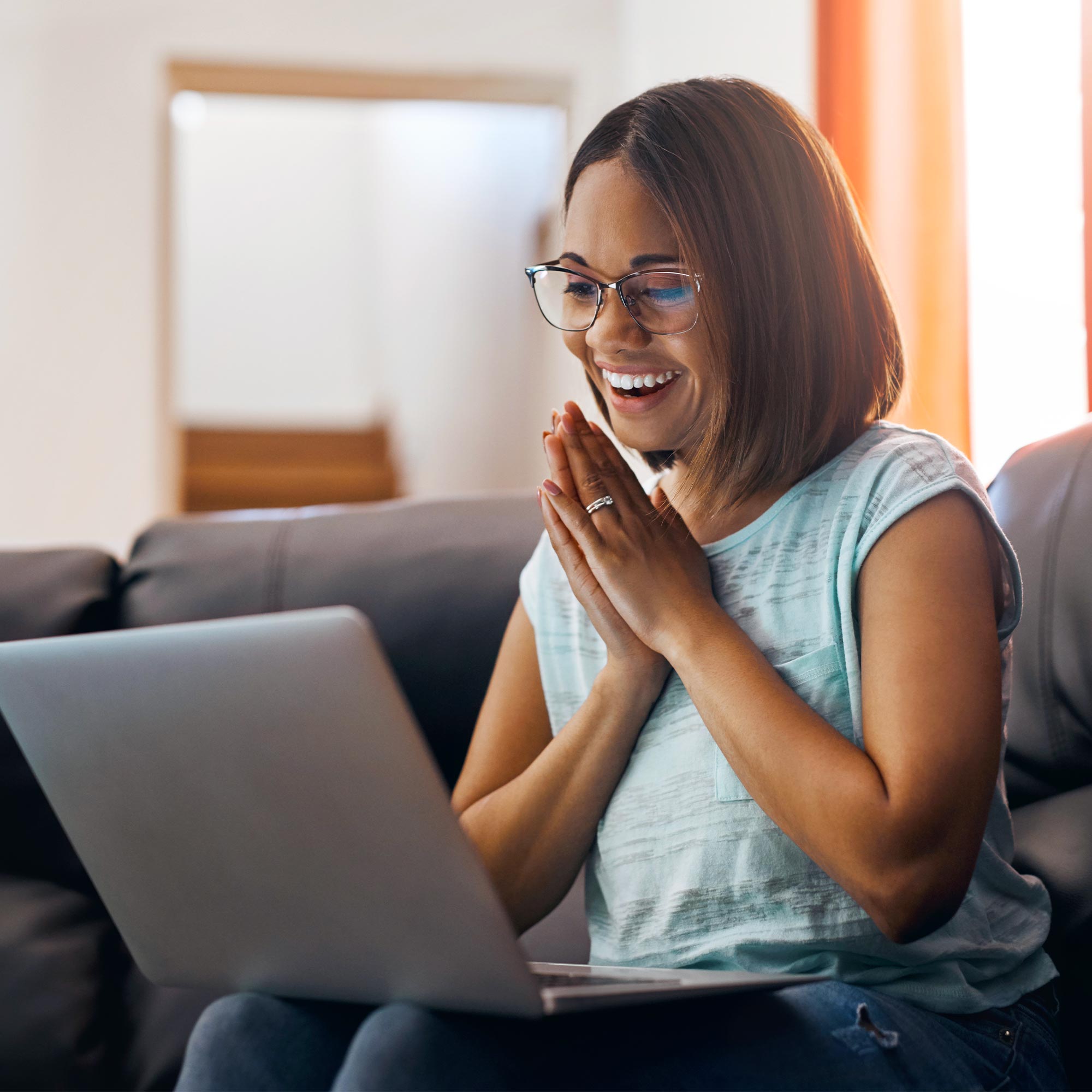 A child sits on her dad's lap as they both look at the computer.