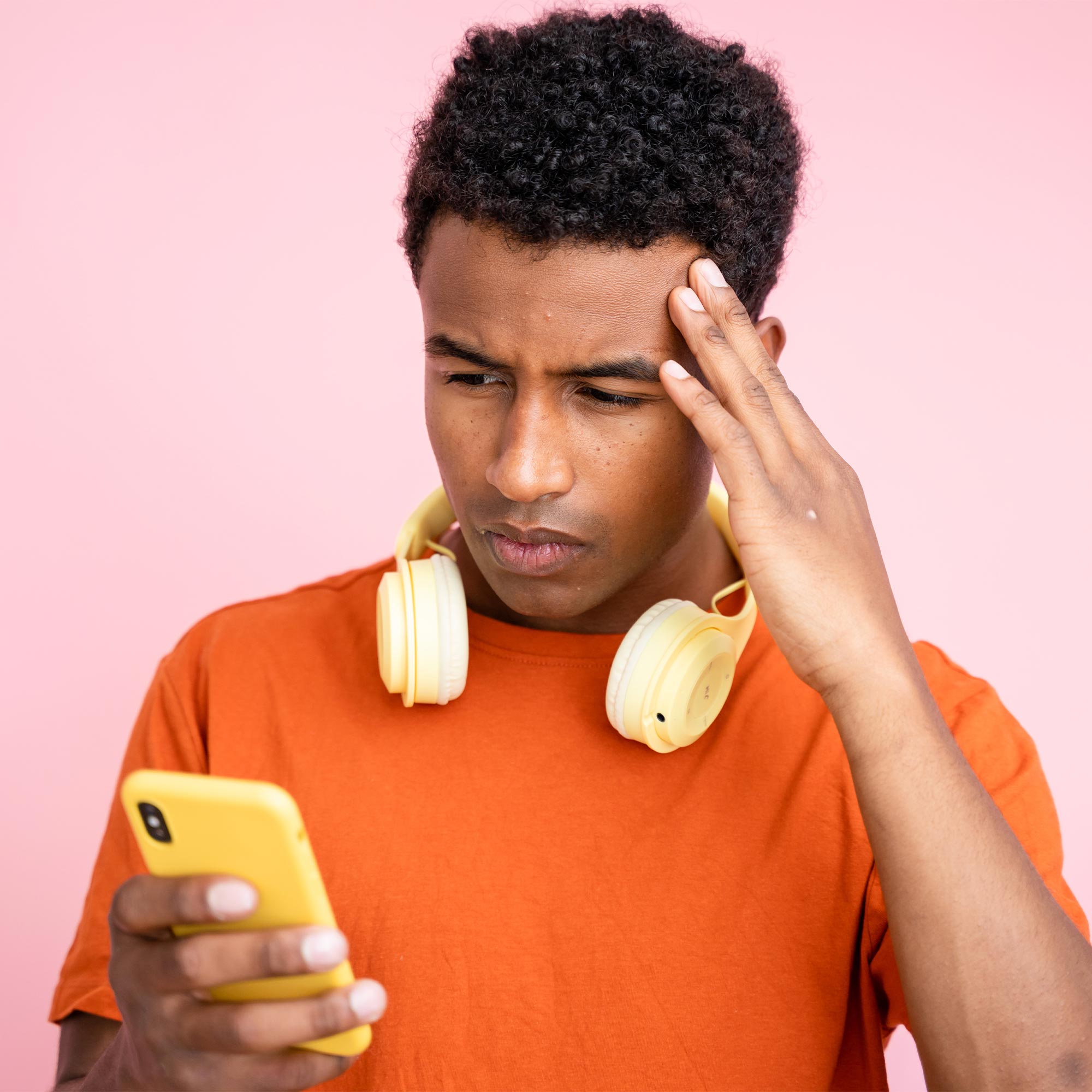 A woman wearing a striped shirt looking very concerned at her phone.