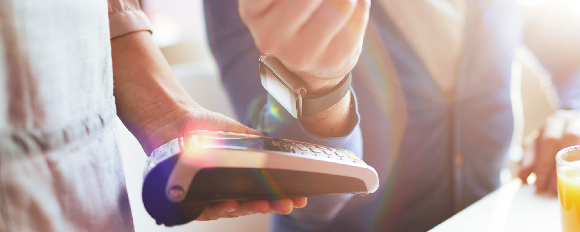 A woman uses her watch to pay digitally for a recent purchase.