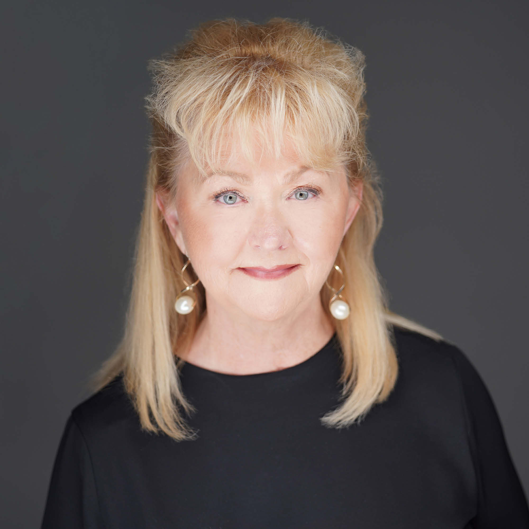 a woman with blonde hair wearing earrings