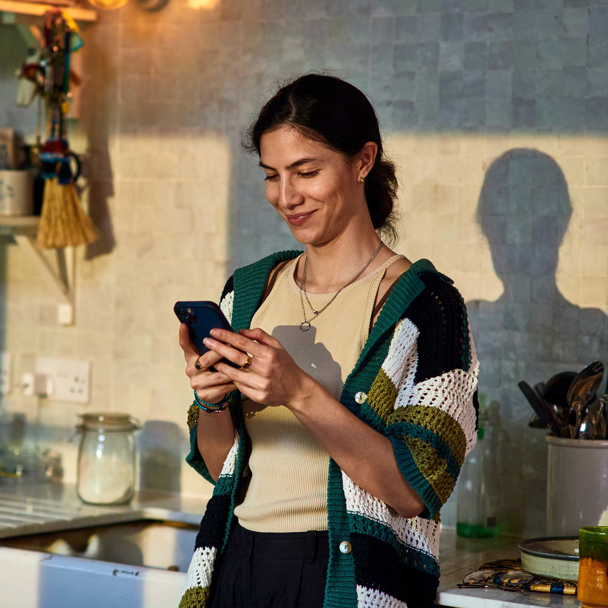 a woman in a sweater looking at a phone