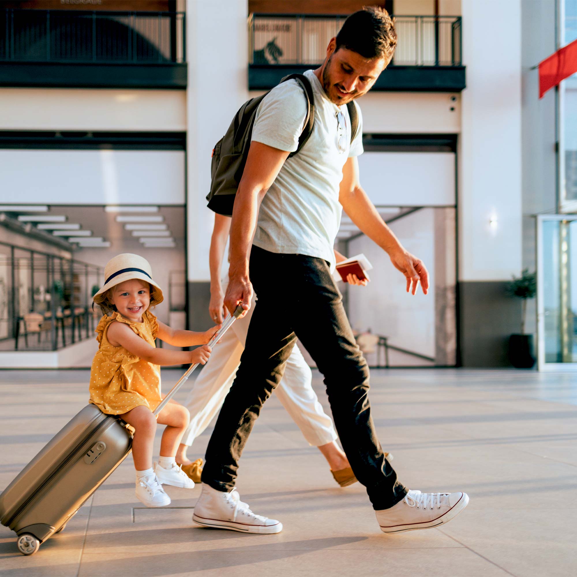a man and a child pulling a suitcase