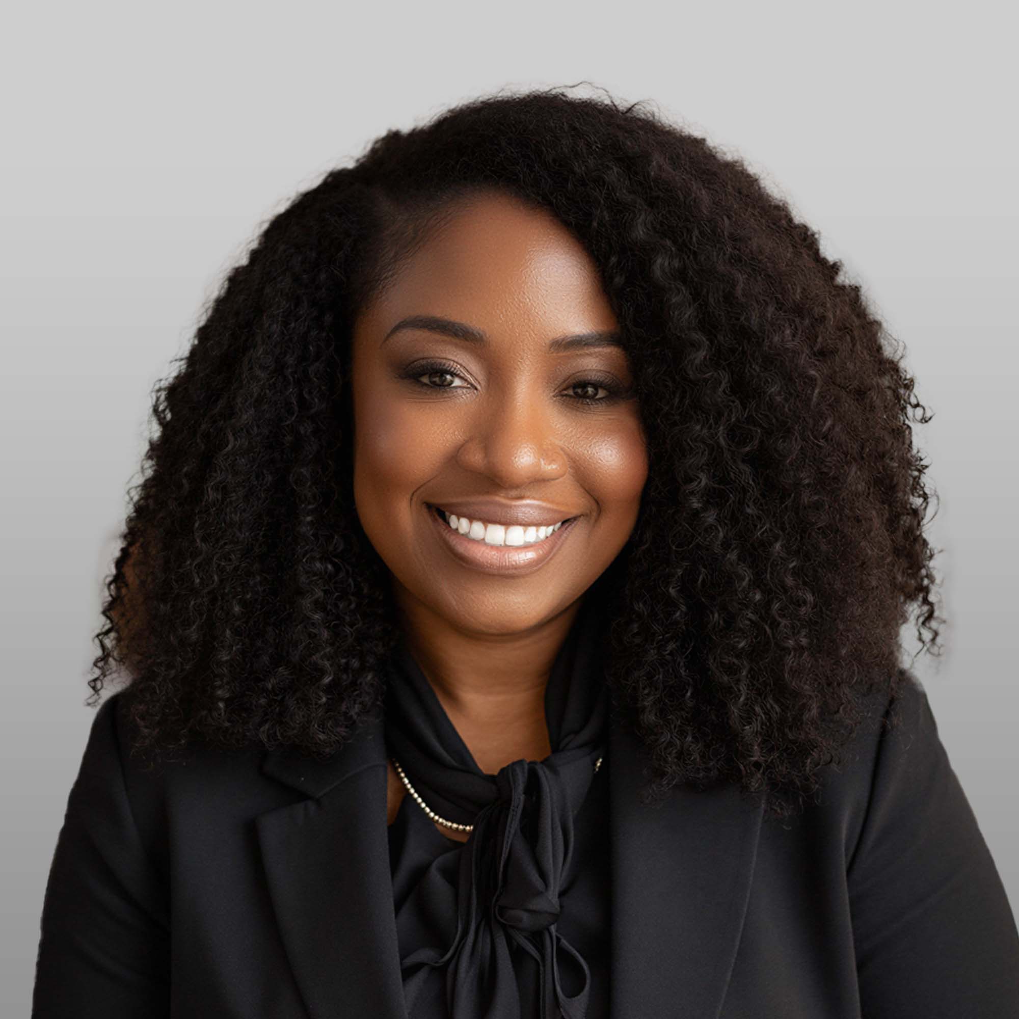 a woman with curly hair wearing a black suit