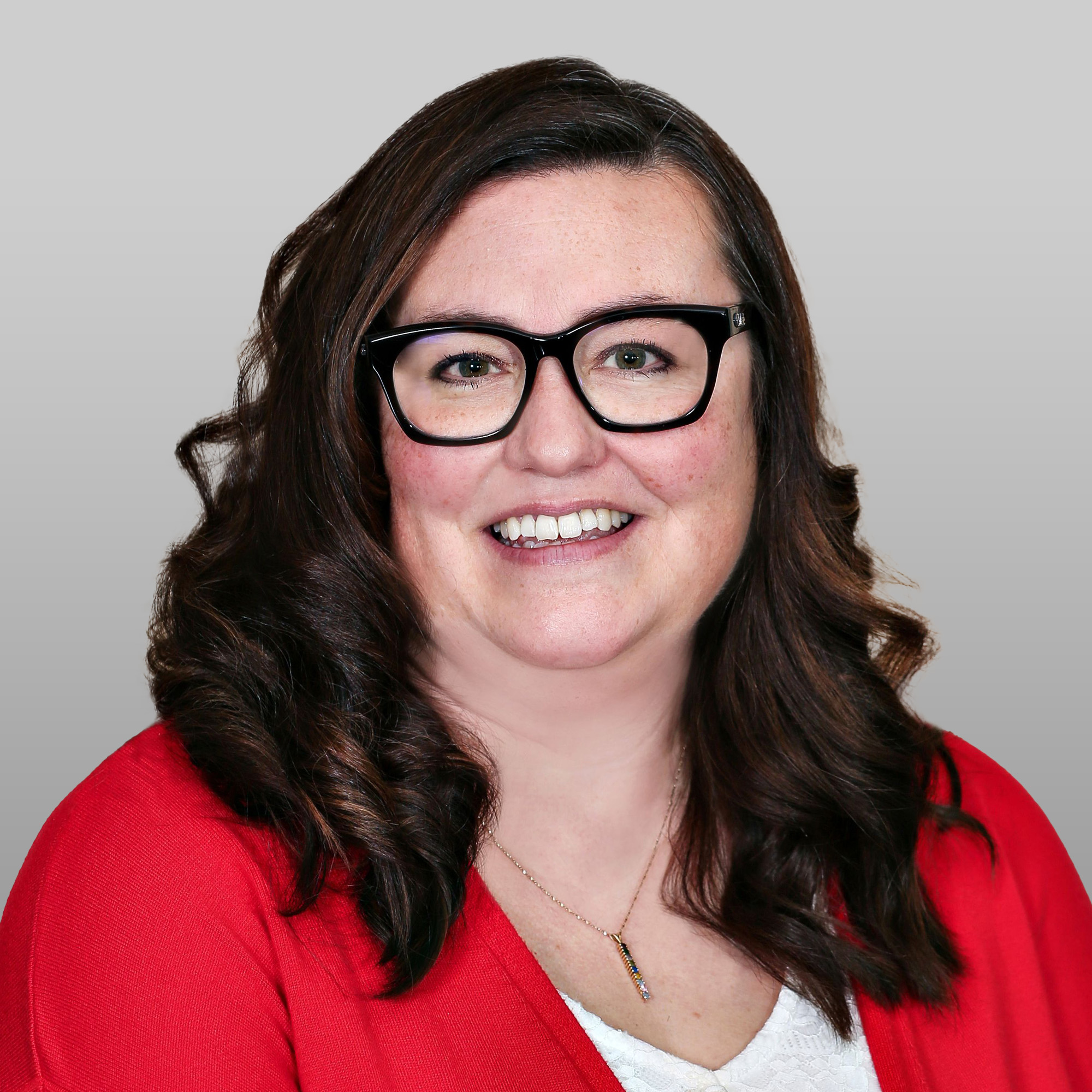 a woman wearing glasses and a red sweater