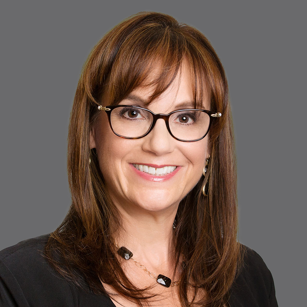 a woman wearing glasses and smiling