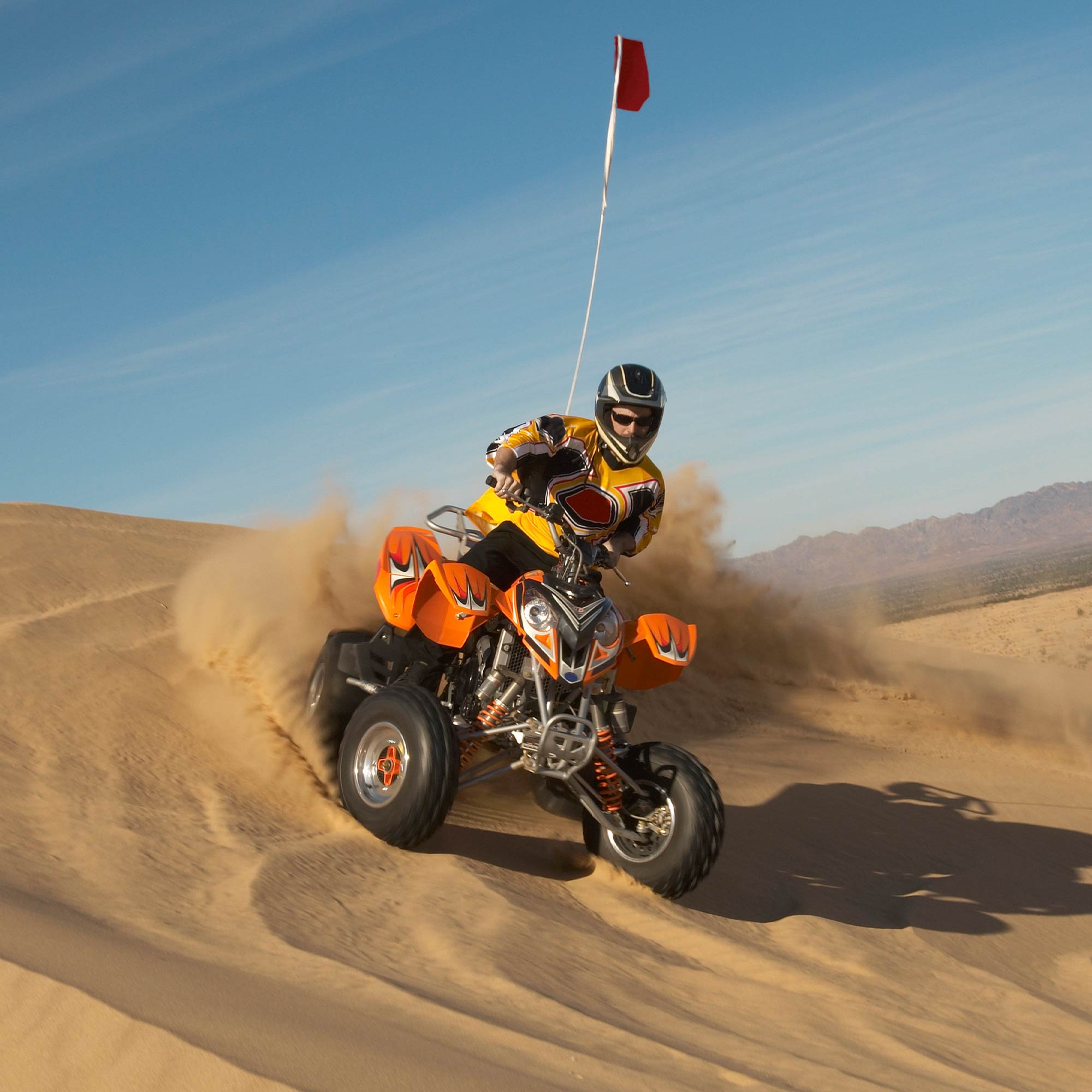 Man on powersport vehicle blazing in the sand.