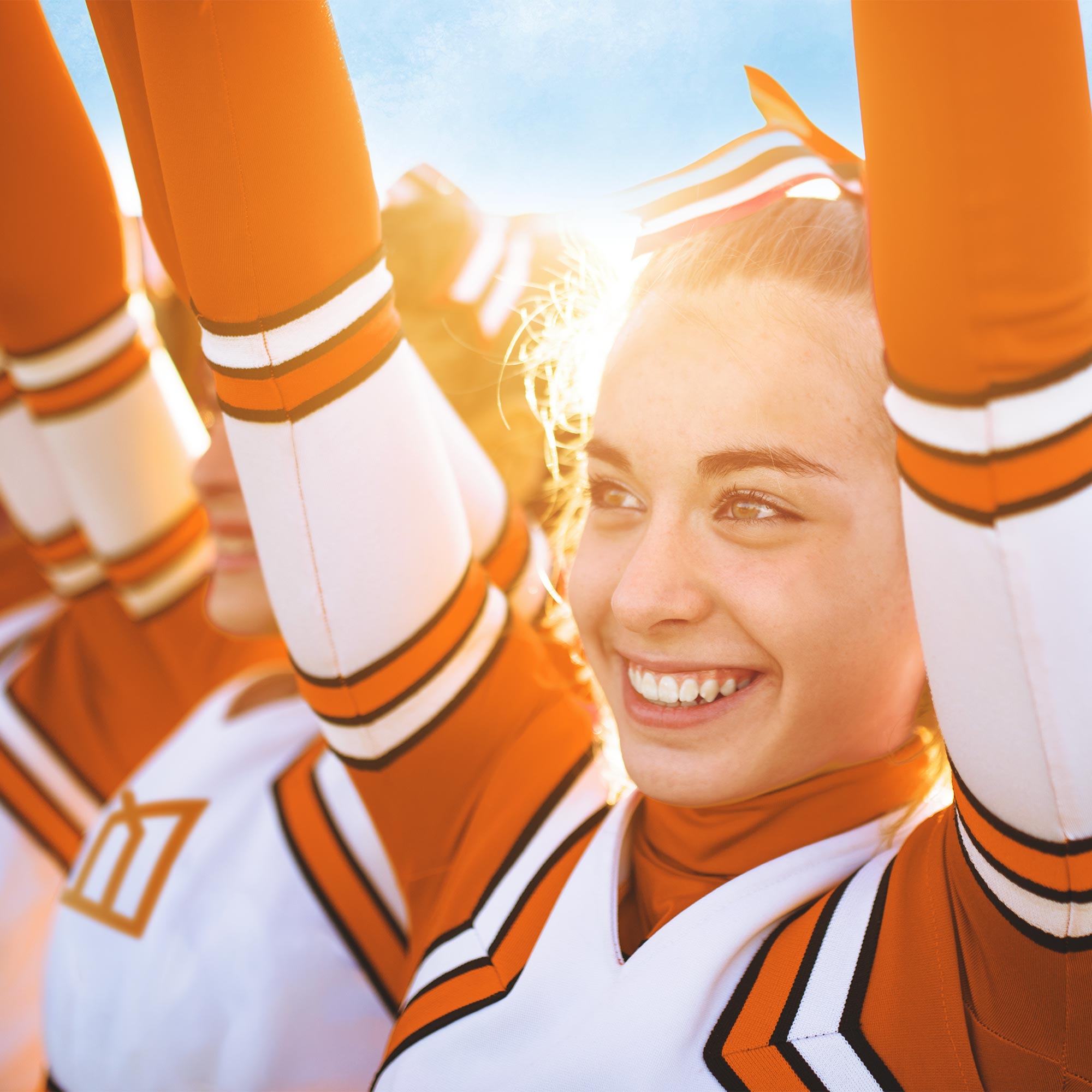 a group of cheerleaders with their arms up