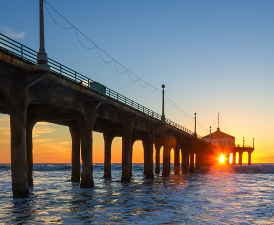 A family of four walk on the beach.